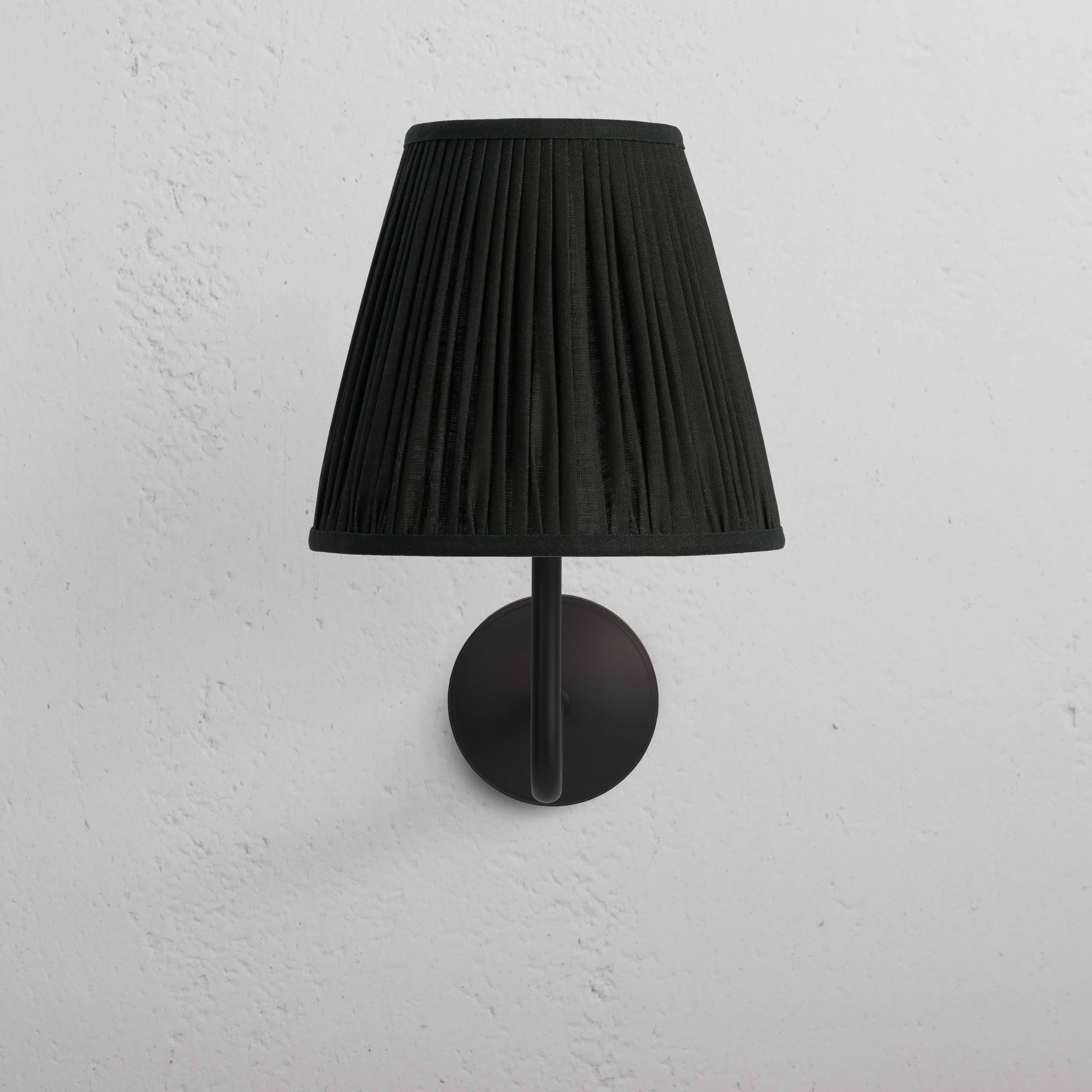 Large Malvern Wall Light in deep green with bronze mount, wall-mounted against a white textured surface.
