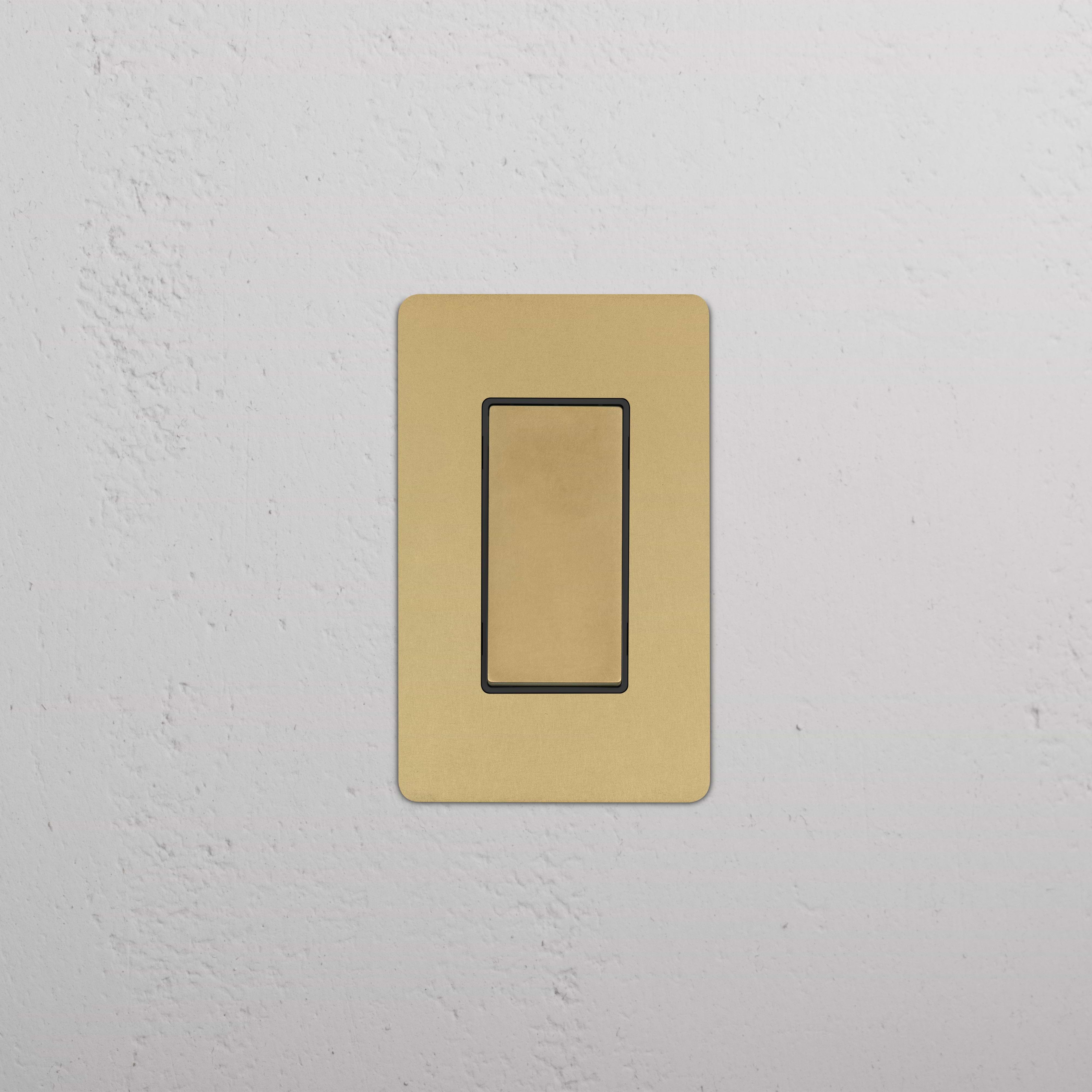 Kew 1G Rocker Switch in antique brass black finish, single gang, shown installed on a white wall.