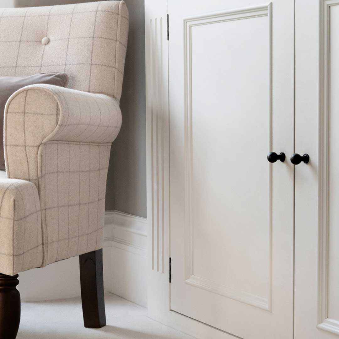 Close-up of the Bayswater Furniture Knob Small in Bronze fitted to a white cabinet door.