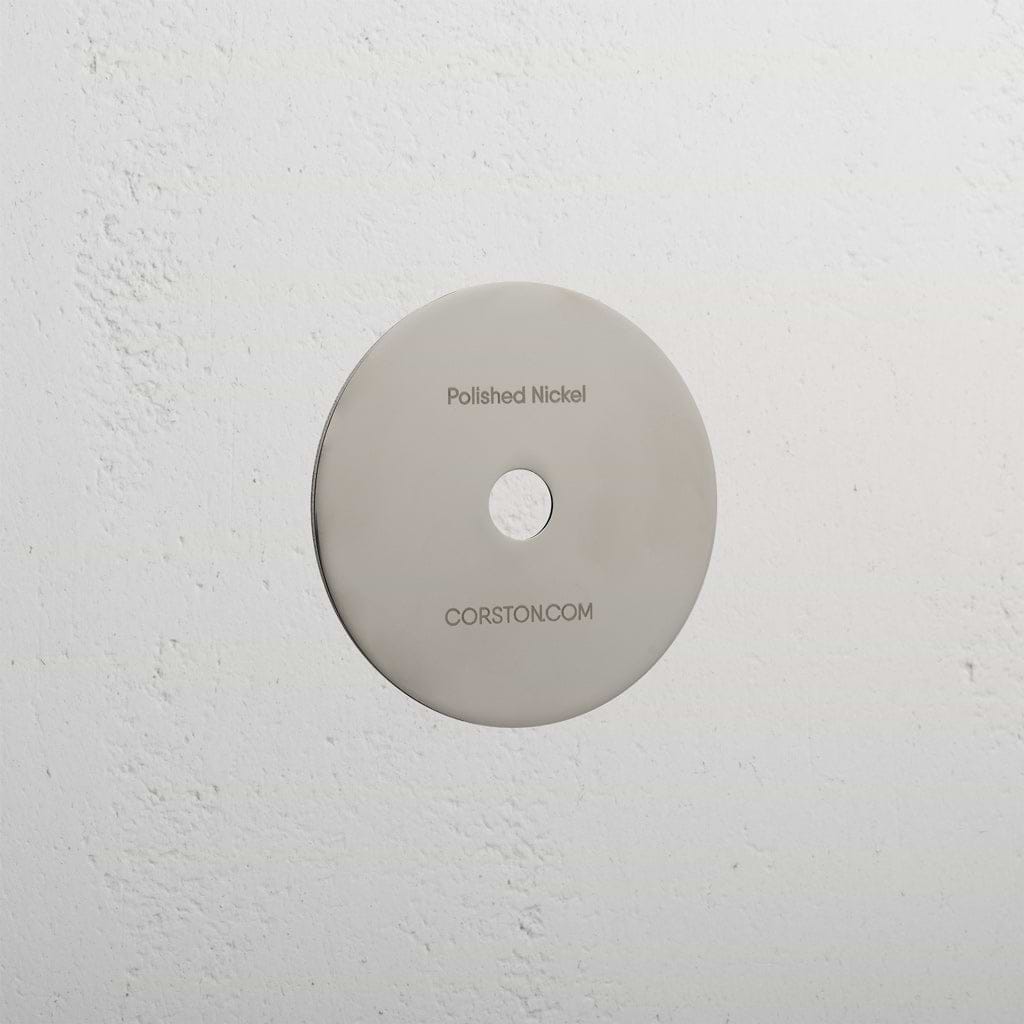 Polished Nickel sample finish disc labeled 'CORSTON.COM' displayed on a textured white background.