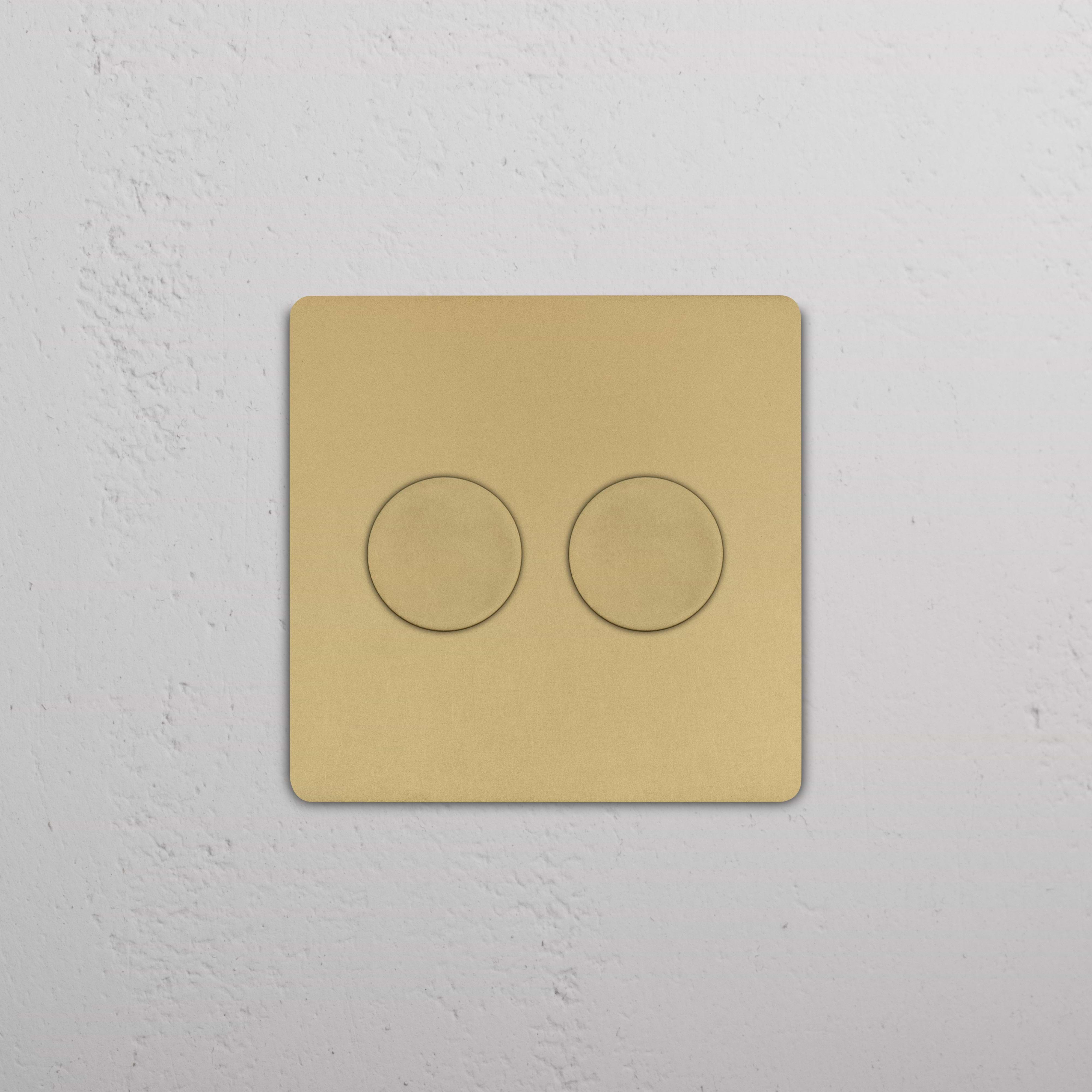 Grove 2G Dimmer Switch in Antique Brass with two round dimmer knobs mounted on a white wall.
