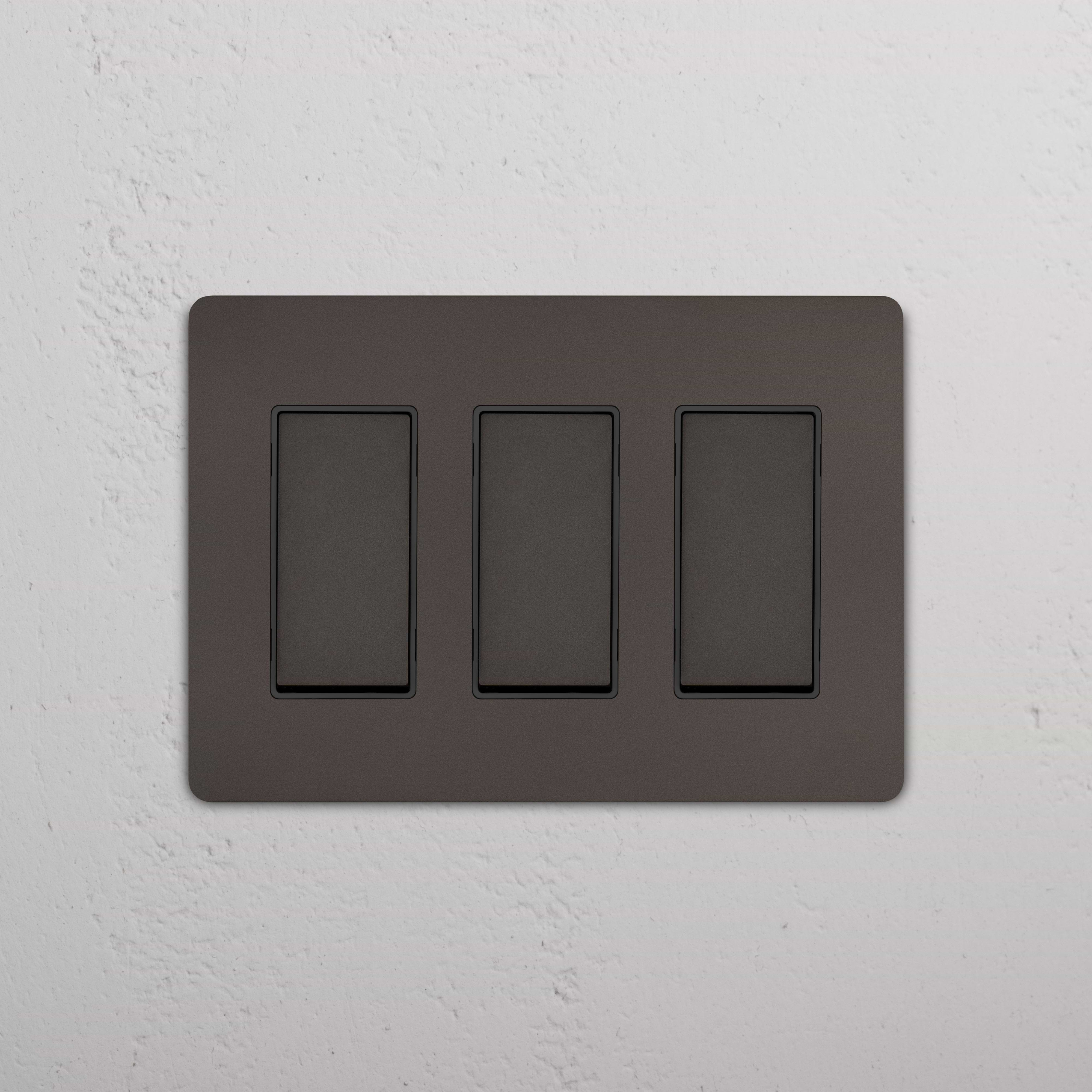 Grove 3G Rocker Switch in Bronze Black with three rectangular switches on a sleek, dark panel.