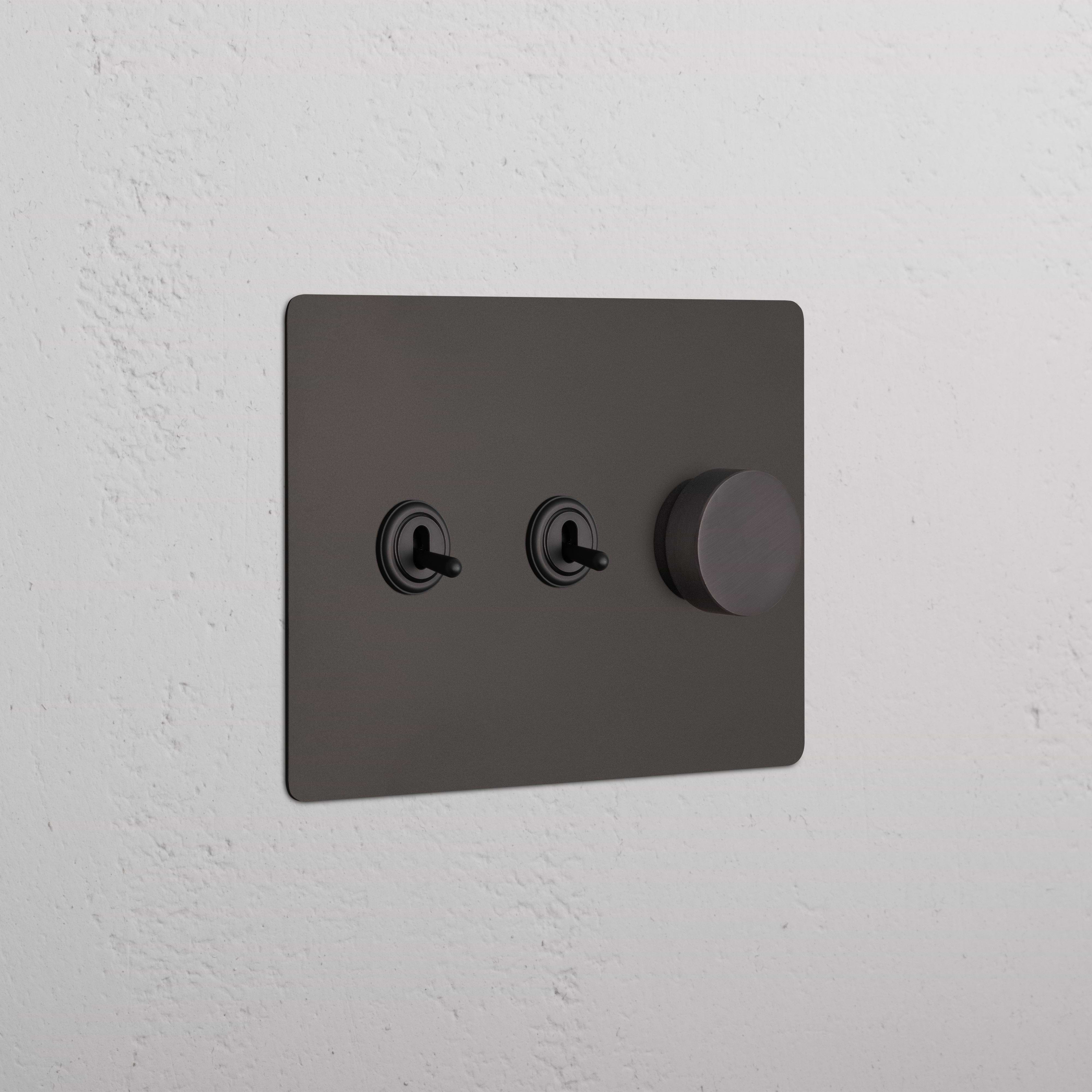 Kew 3G 2x Toggle & Dimmer Switch in bronze with two toggle switches and one round dimmer knob.