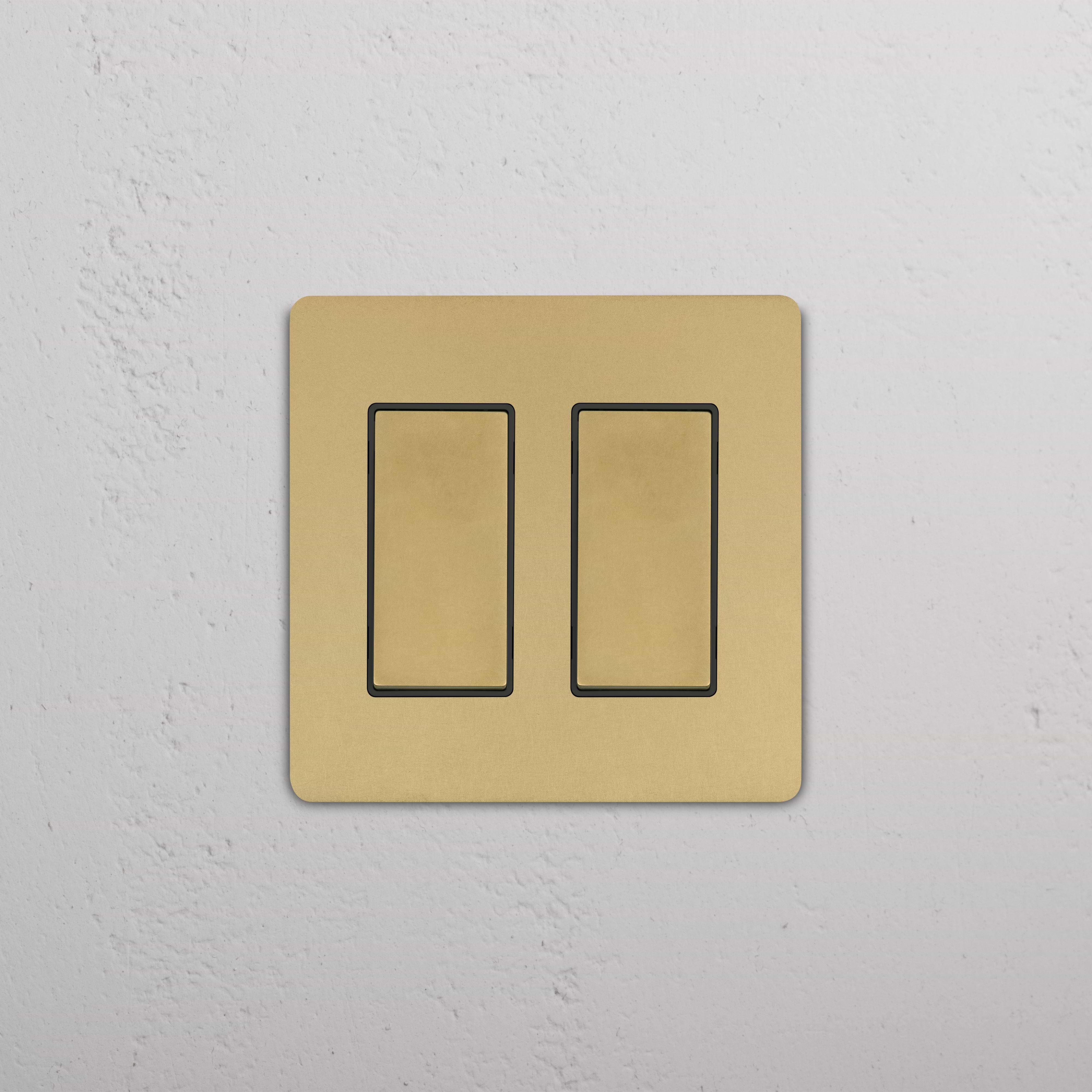 Grove 2G Rocker Switch in antique brass black finish with two rectangular switches, mounted on a wall.