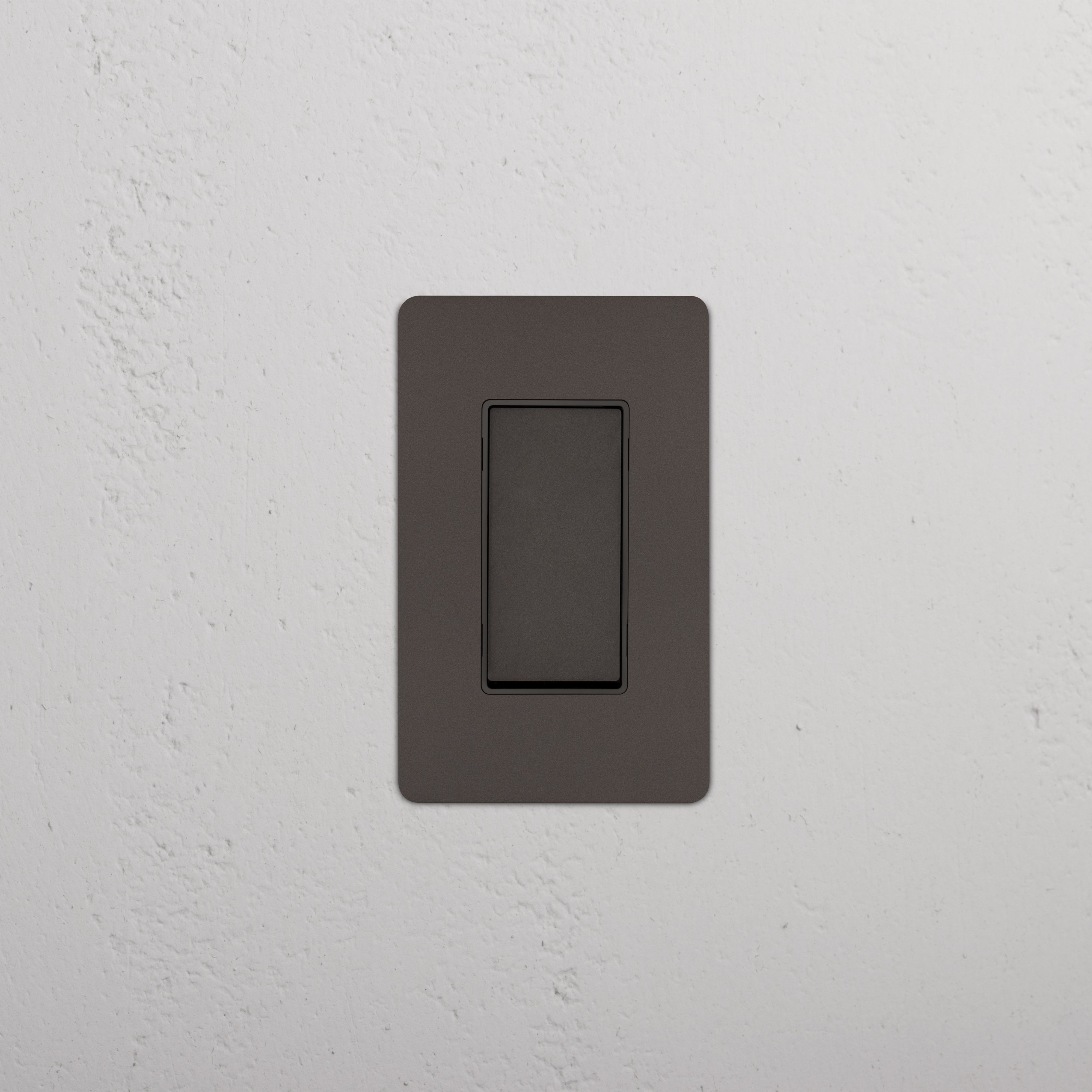 Kew 1G Double Pole Rocker Switch in Bronze Black, mounted on a white textured wall, switch in off position.
