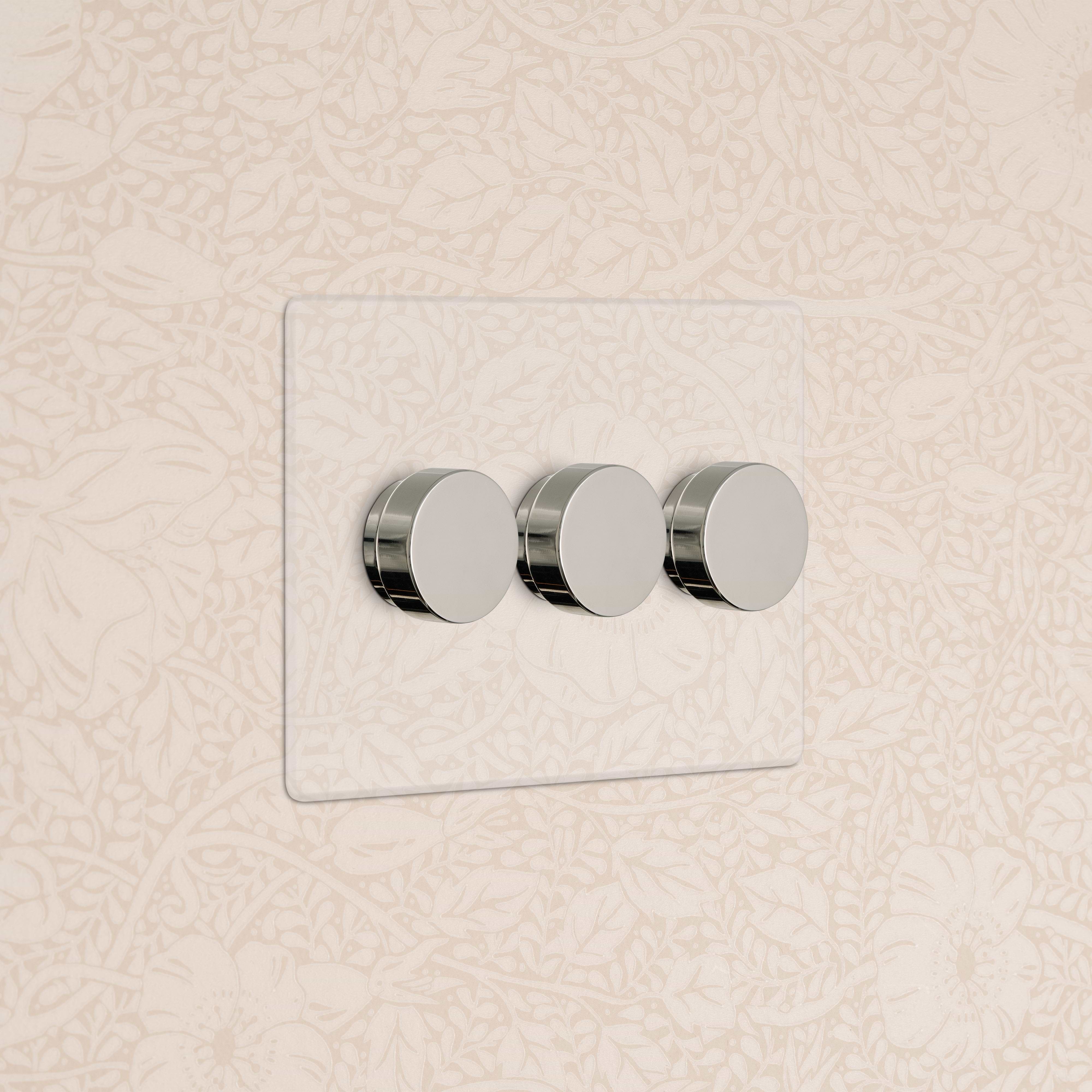 Kew 3G Dimmer Switch in Clear Polished Nickel with three round dials, mounted on a wall.