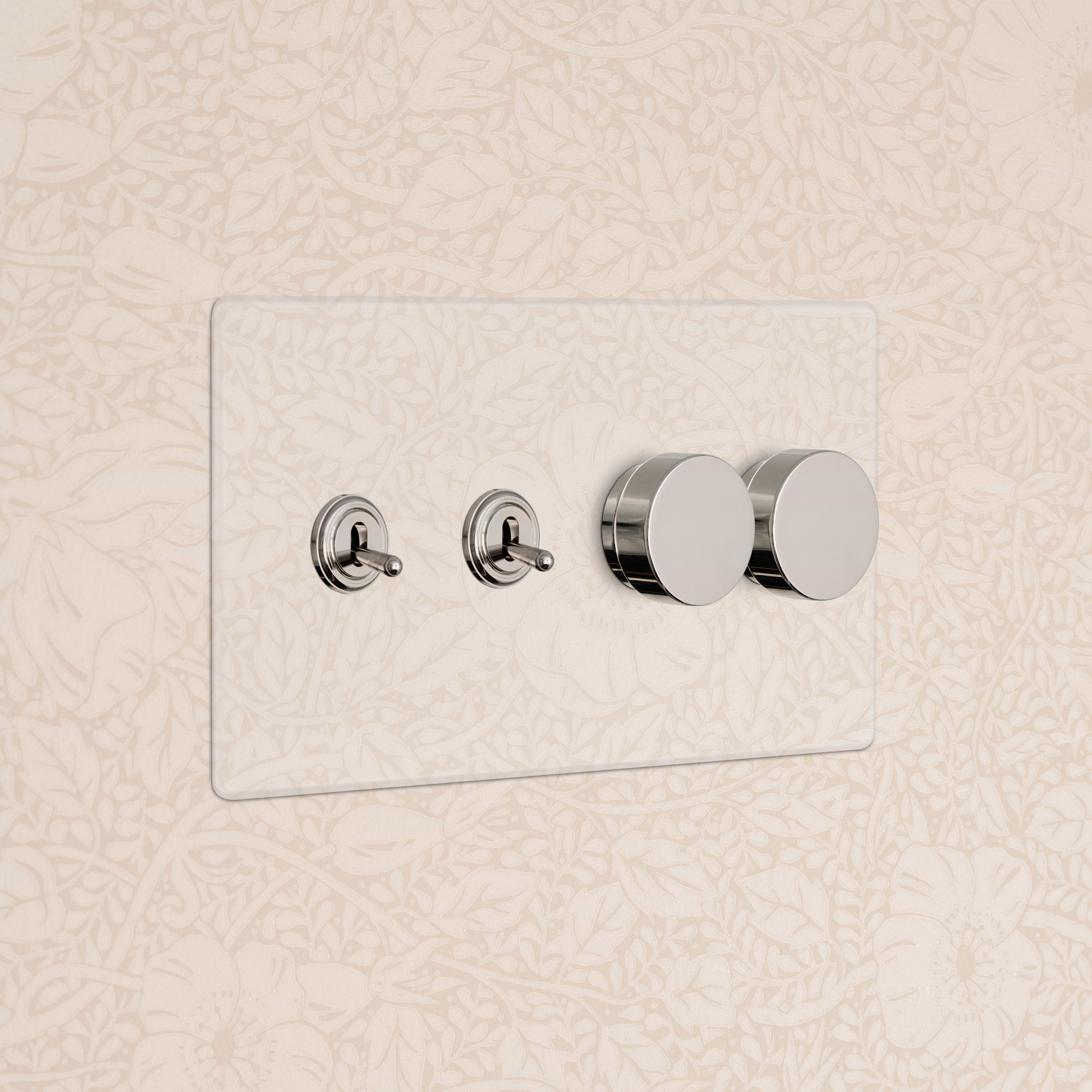 Kew 4G switch panel in clear polished nickel with 2 toggle switches and 2 dimmer dials on a wall.