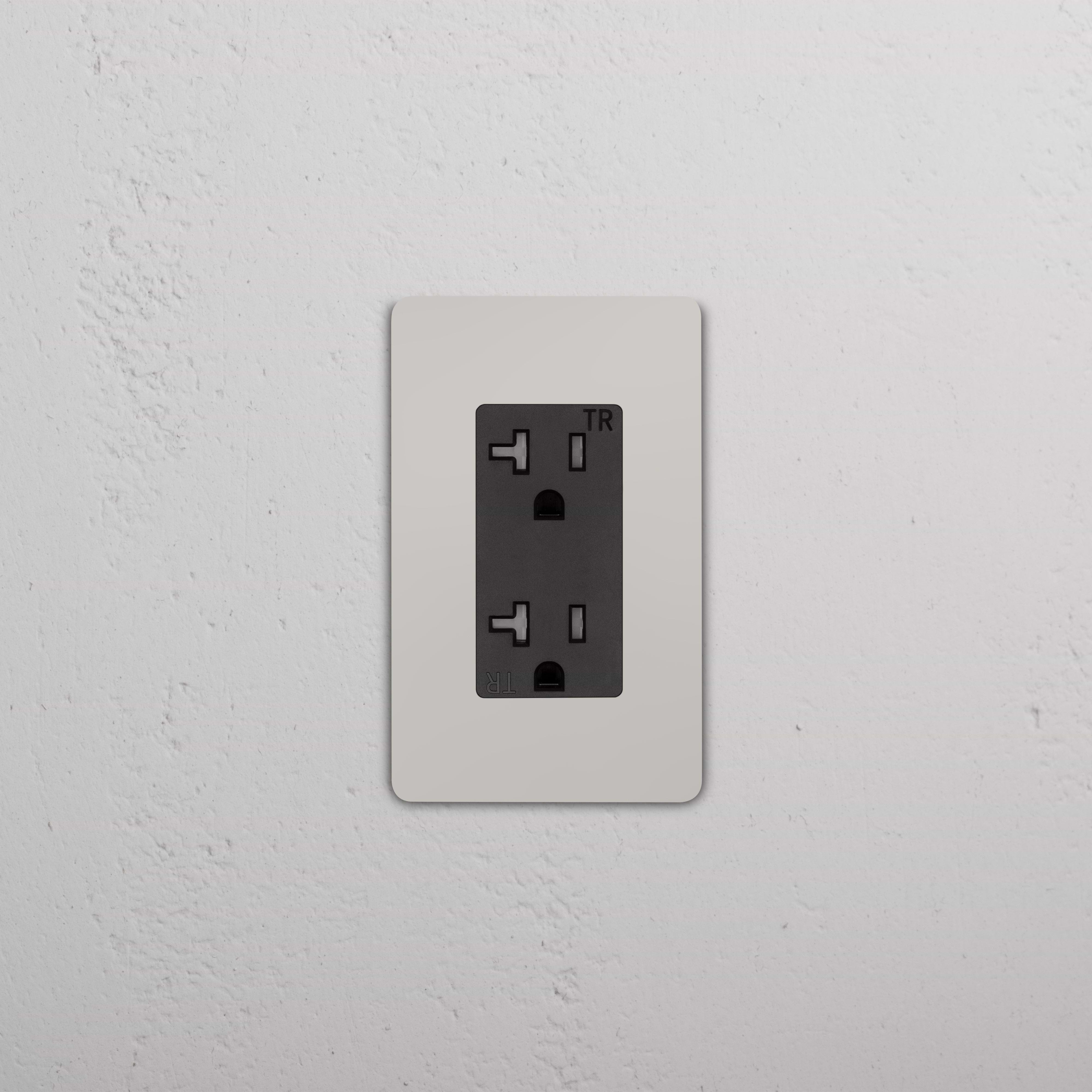 Grove 1G 20A Outlet in polished nickel black finish with rectangular faceplate, mounted on wall.