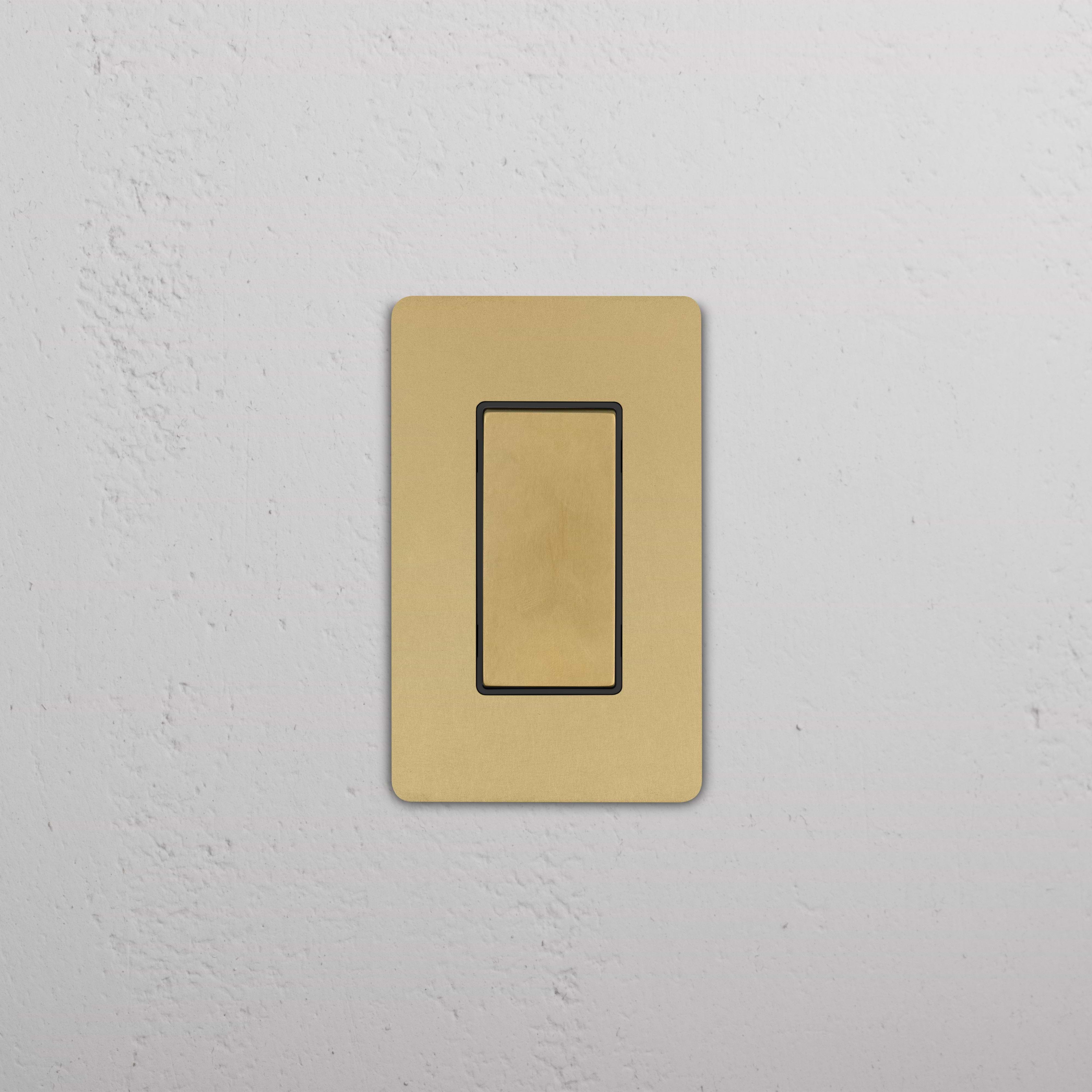 Grove 1G Center Retractive Rocker Switch in Antique Brass Black with rectangular black rocker on brass plate.