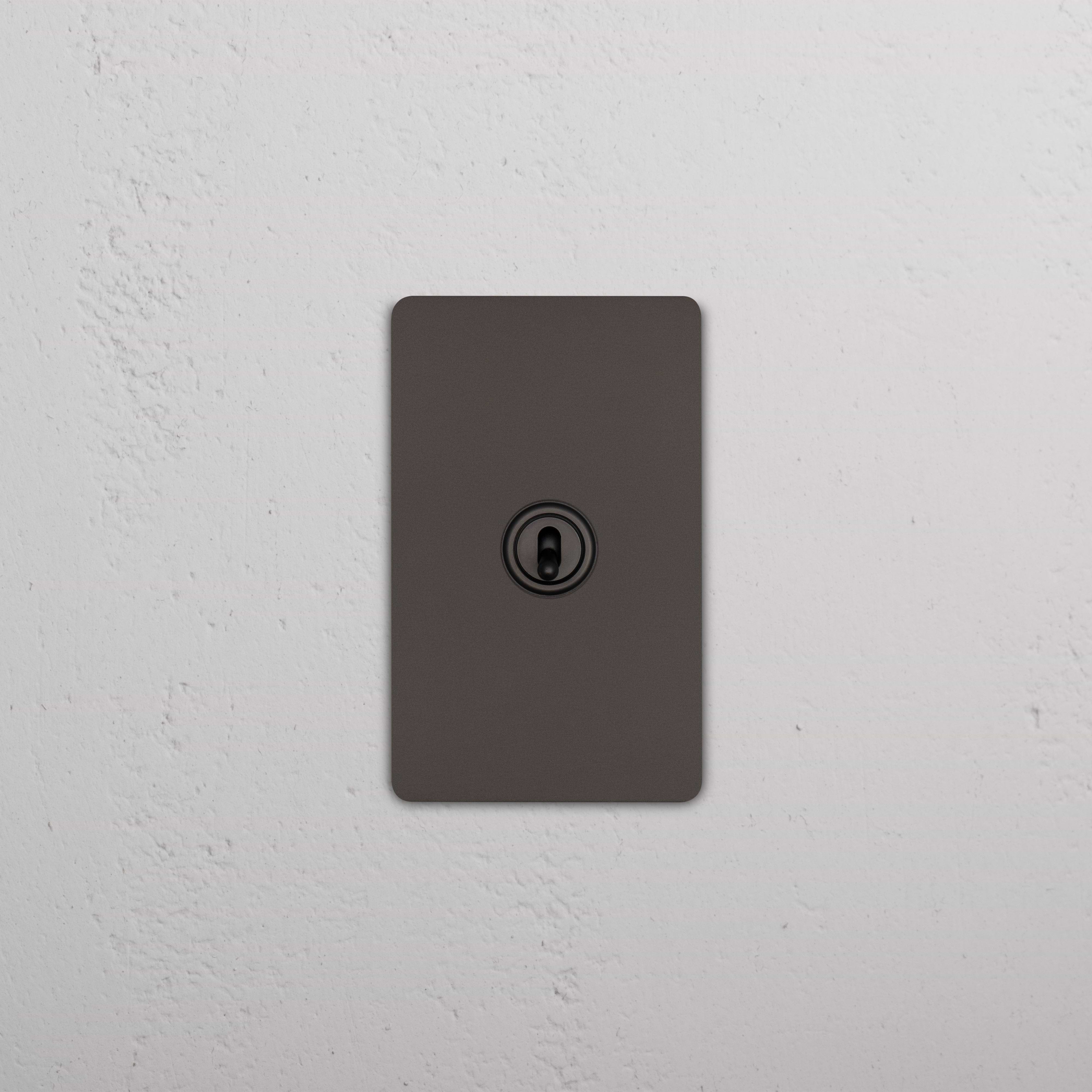 Bronze Grove 1G Four Way Toggle Switch with four toggle levers on a rectangular wall plate.