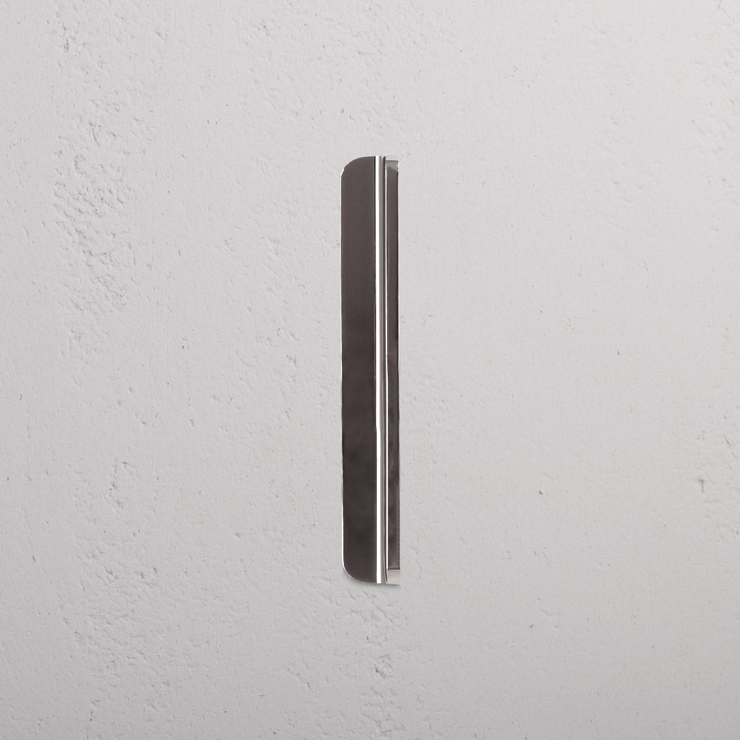 Small Oxford furniture handle in polished nickel, mounted vertically on a white textured surface.
