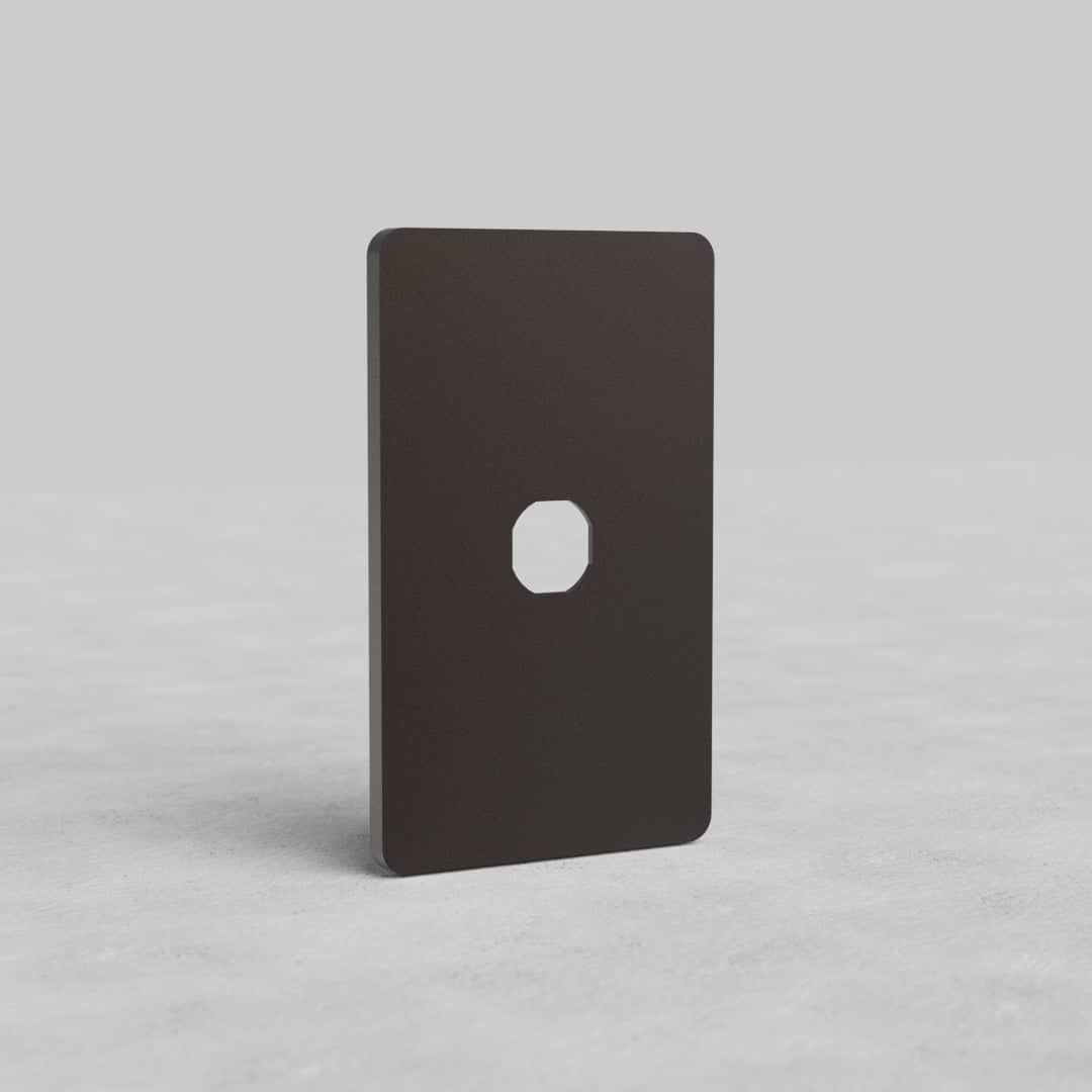 Bronze 1G Switch Plate Grove US with central cutout, shown upright on a light, textured surface.