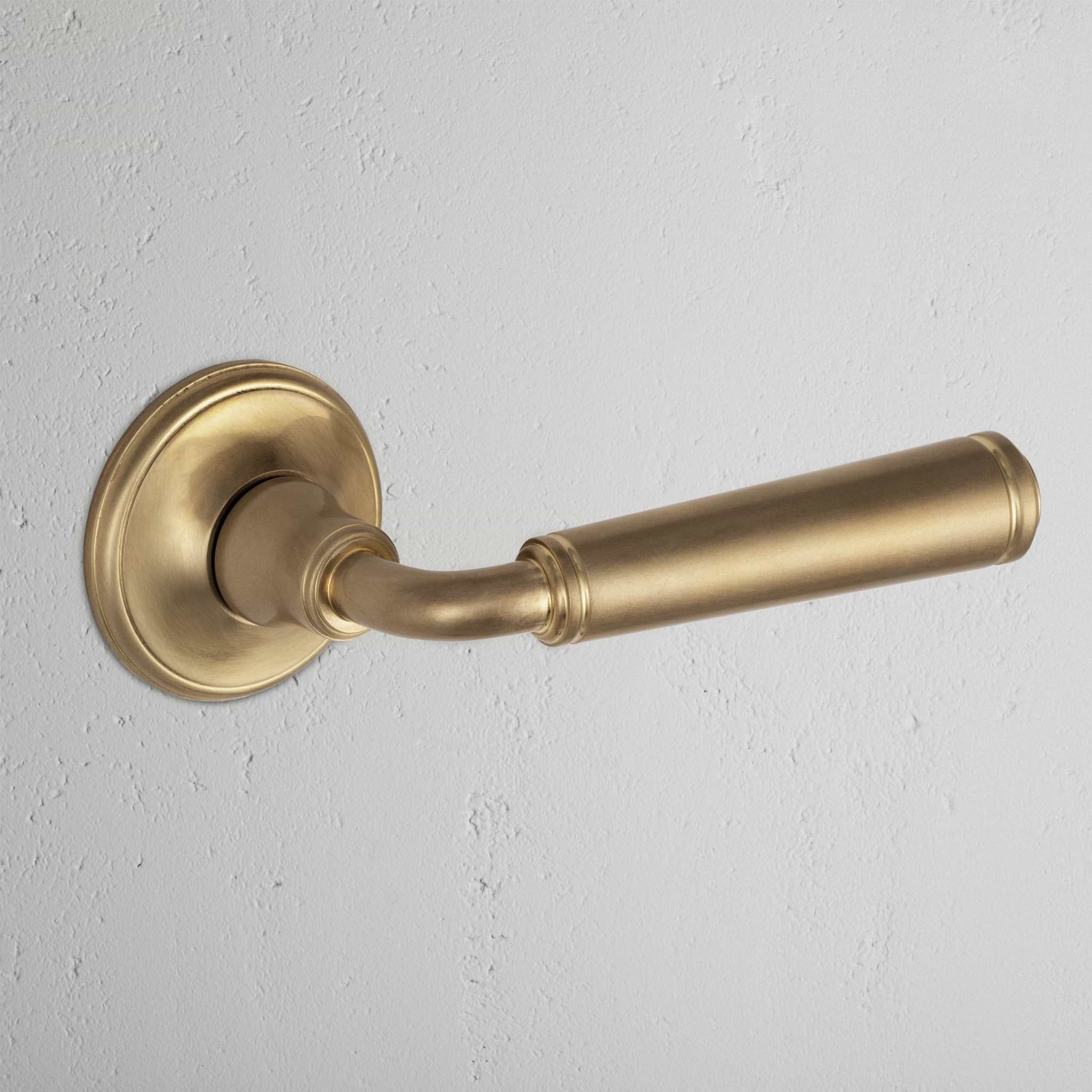 Digby Passage Door Handle Set in antique brass with a brushed finish, mounted on a round base plate.