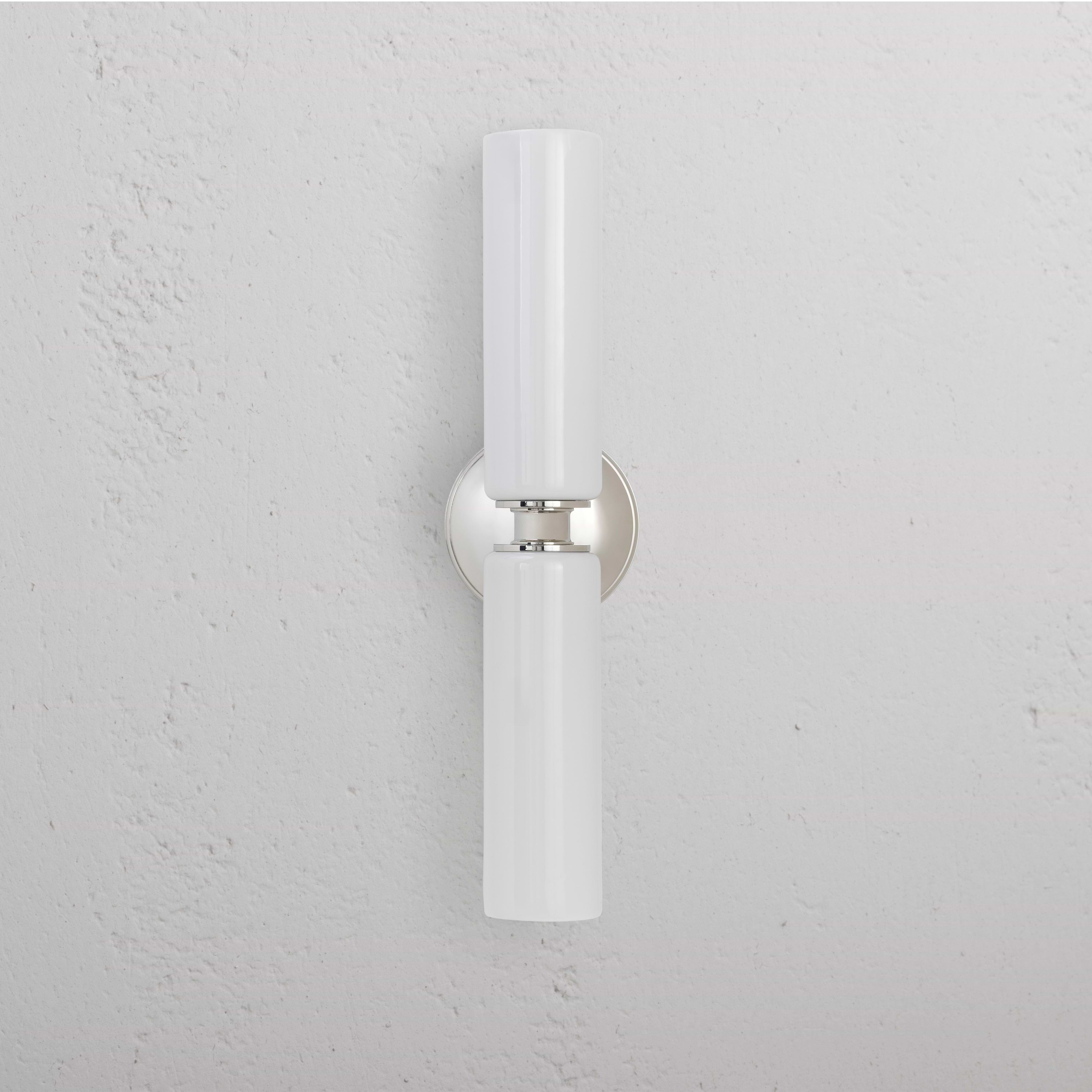 Claremont Medium Wall Light in fine white porcelain with a polished nickel base, mounted on a wall.