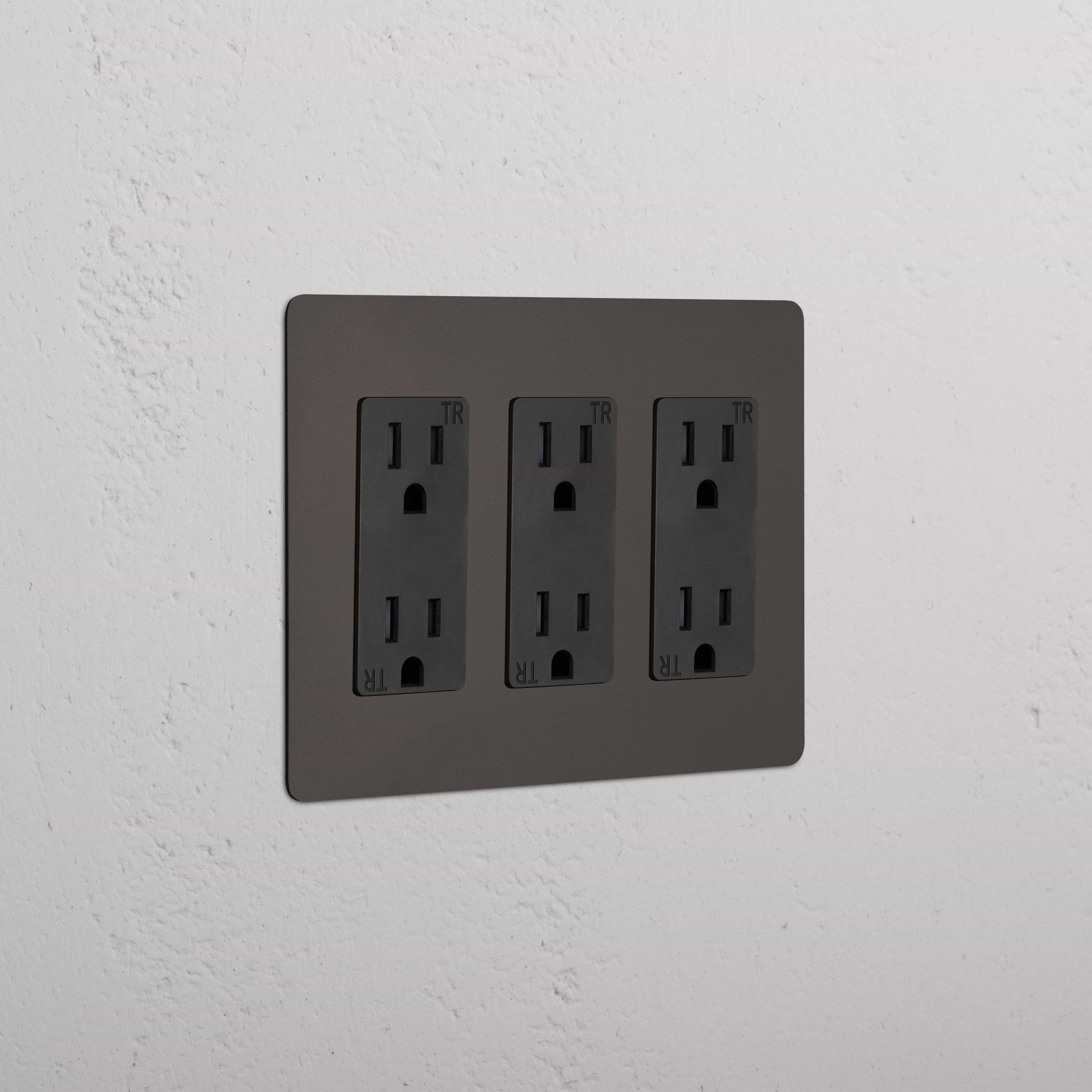 Kew 3G Outlet in Bronze Black with three double power sockets, mounted on a white textured wall.