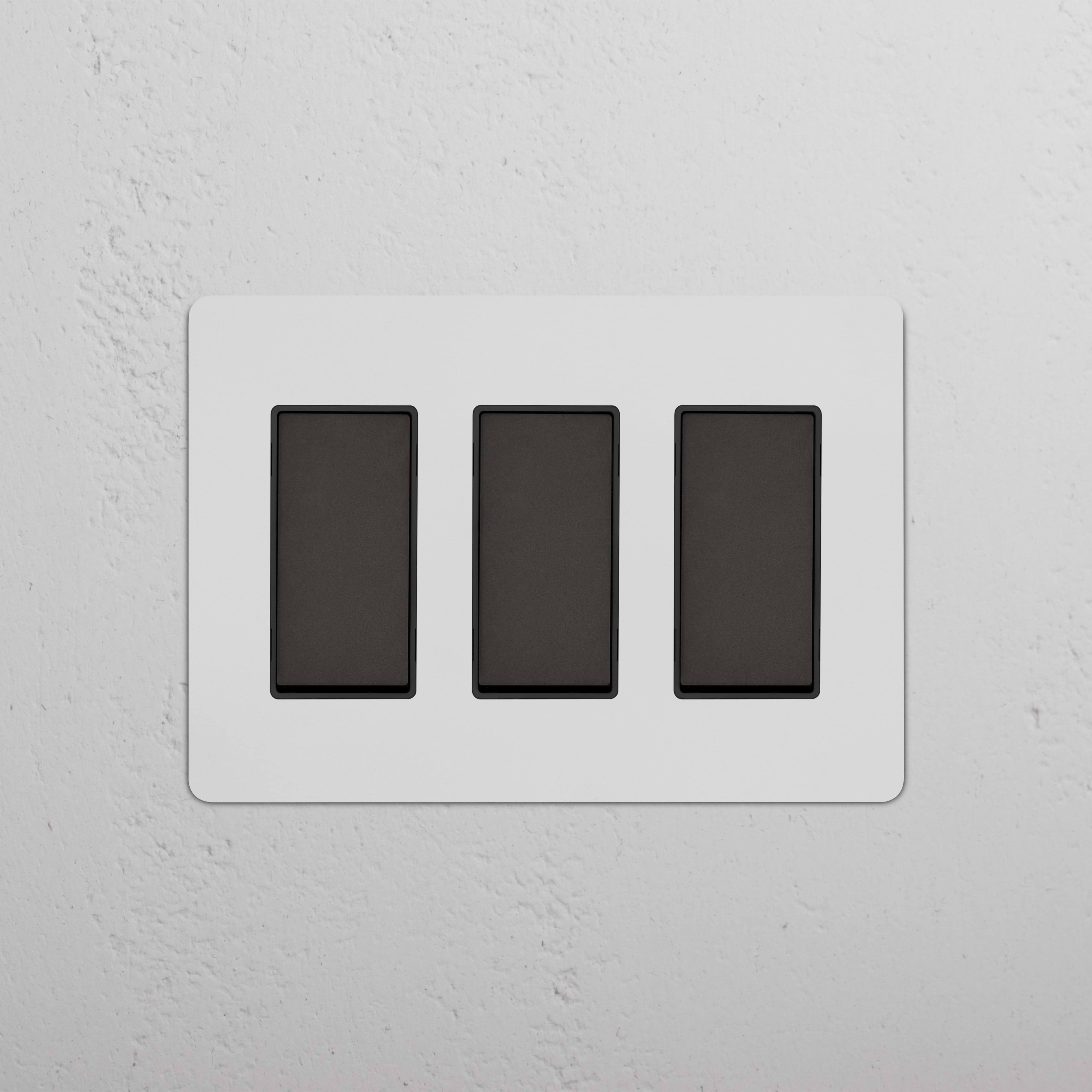 Kew 3G Rocker Switch in Paintable Bronze Black finish with three side-by-side black rocker switches.