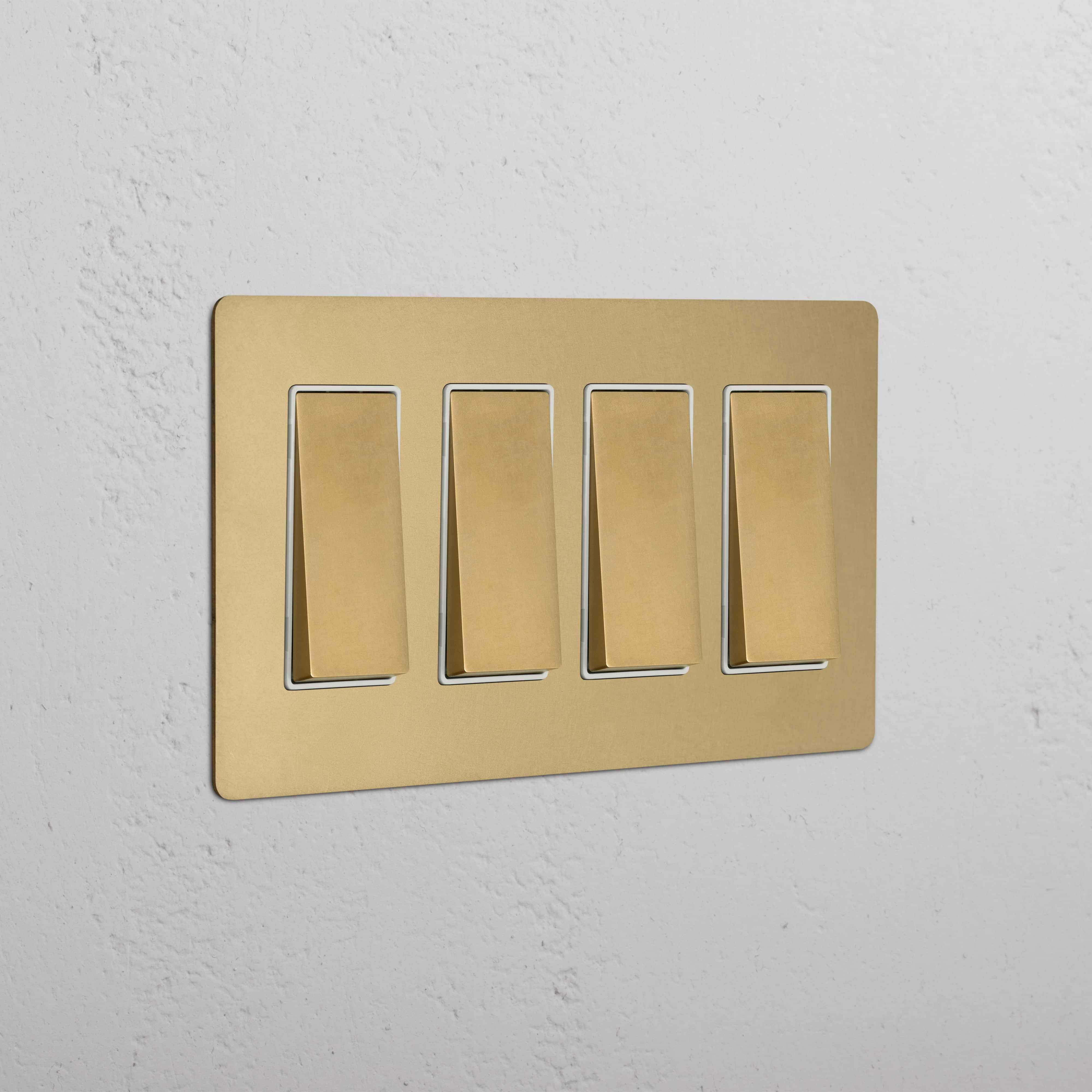 Kew 4G Rocker Switch in antique brass with white inserts, shown mounted on a wall.