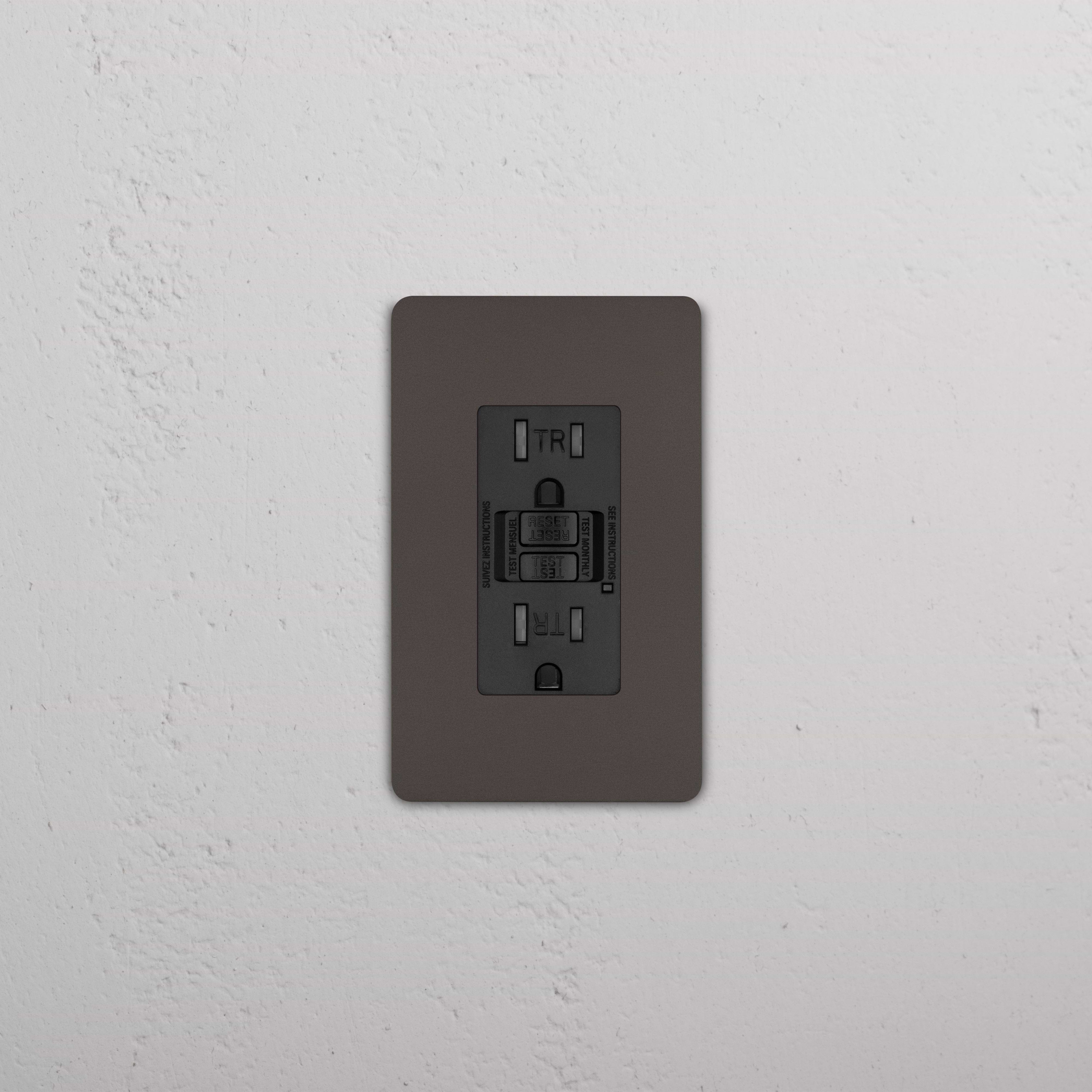 Grove 1G 15A GFCI Outlet in bronze black with “Test” and “Reset” buttons shown installed on a wall.