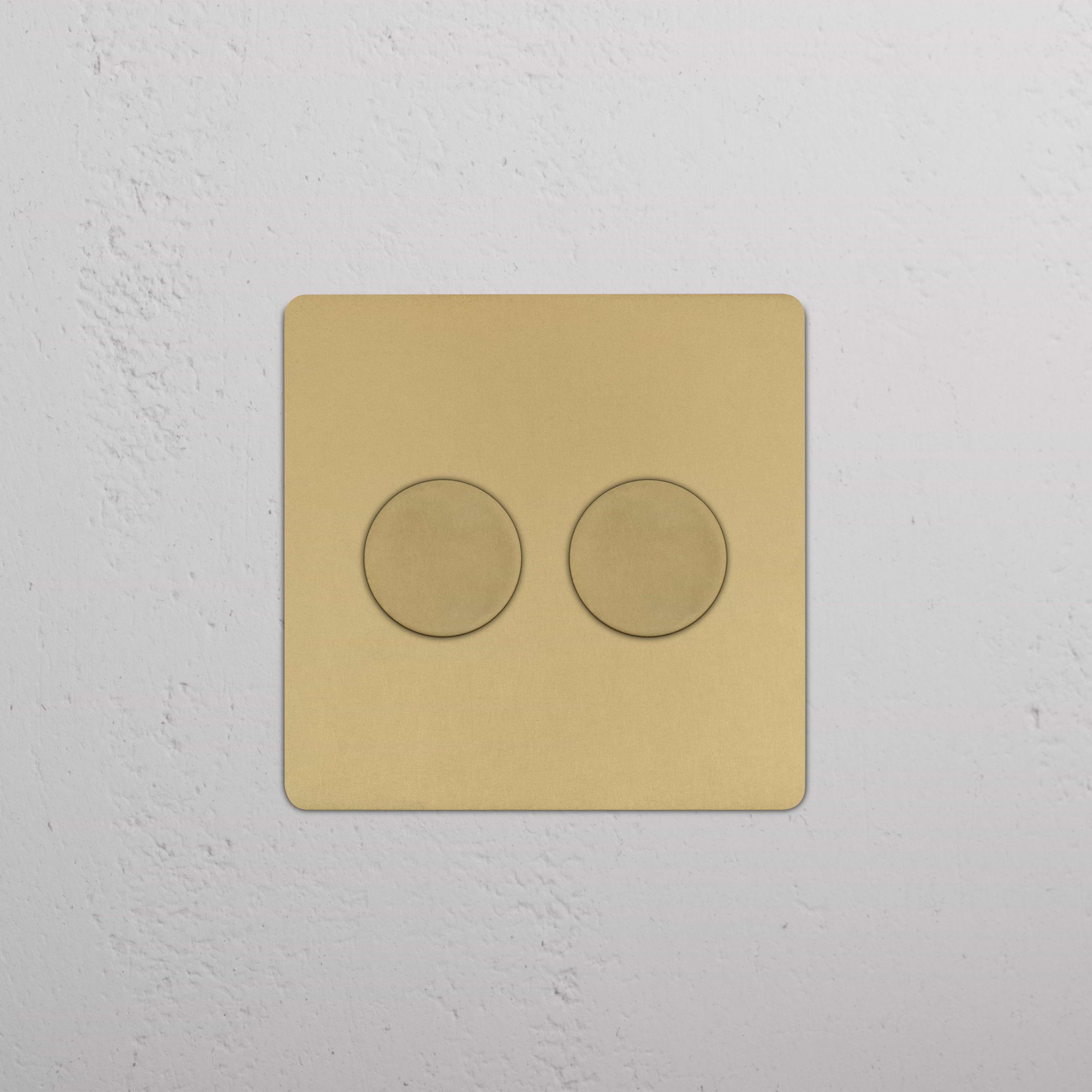 Kew 2G Dimmer Switch in Antique Brass finish with two round dials, mounted on a white wall.