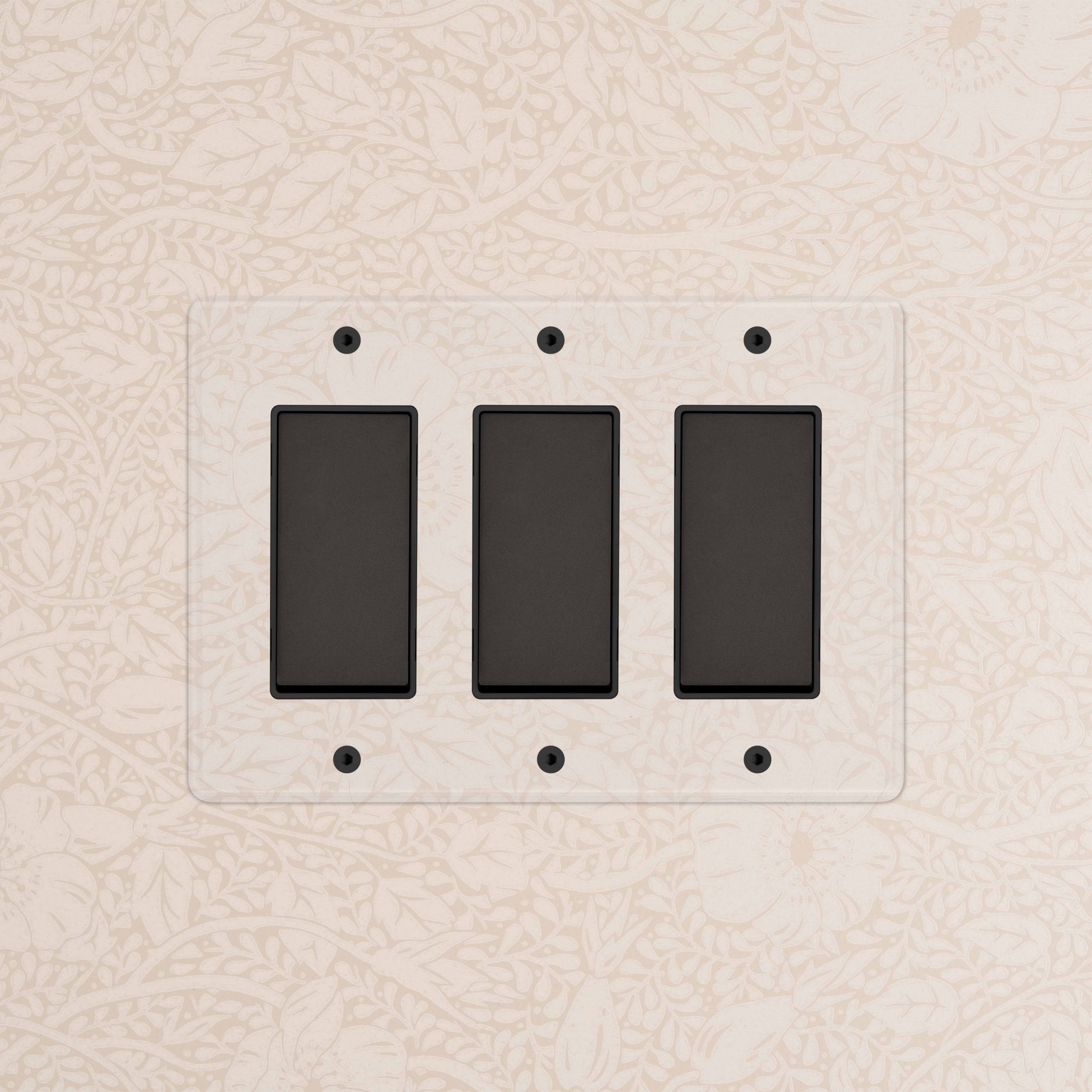 Kew 3G Rocker Switch in Clear Bronze Black finish with three rectangular switches on a decorative wall.