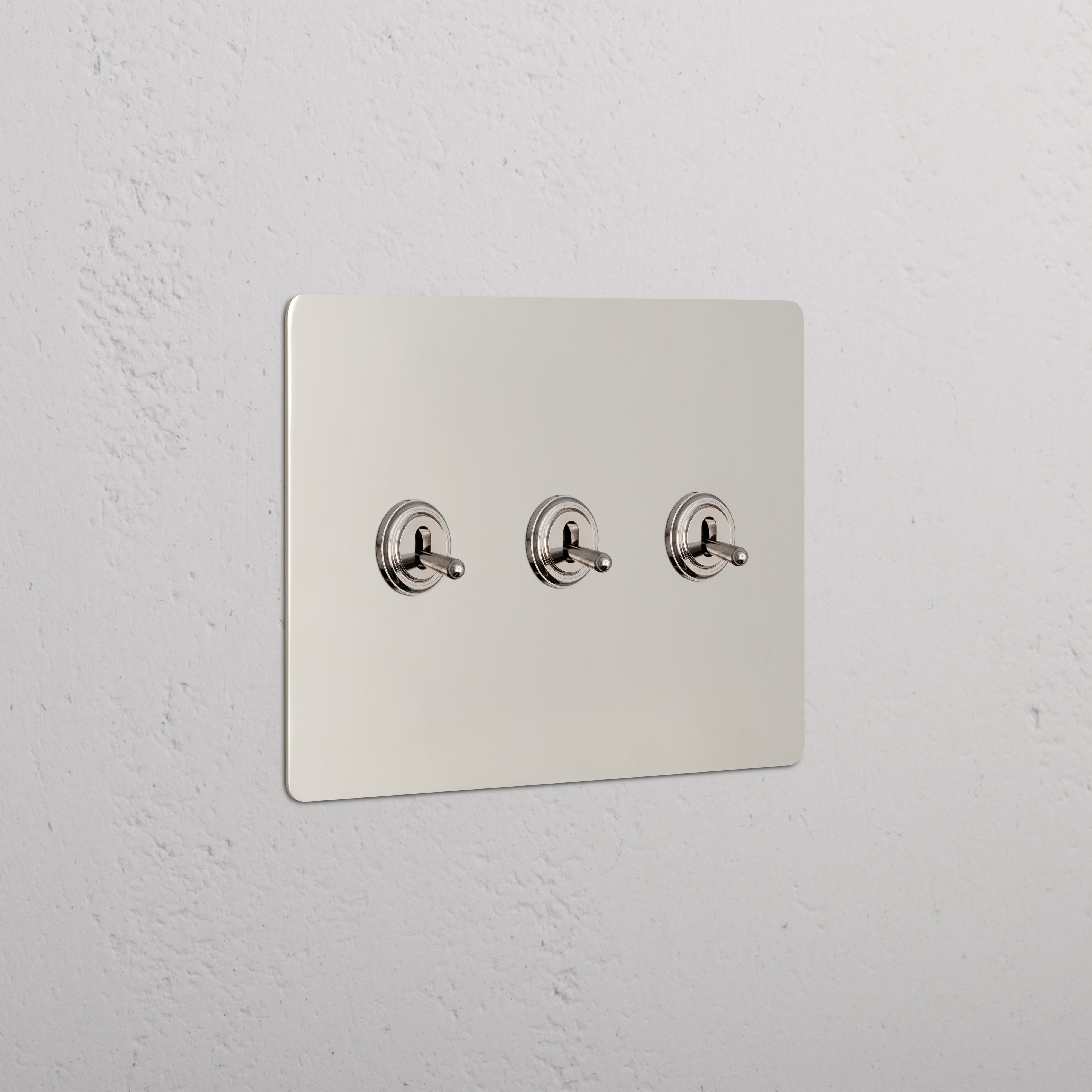 Kew 3G Toggle Switch in polished nickel finish, wall-mounted with three aligned toggle switches.