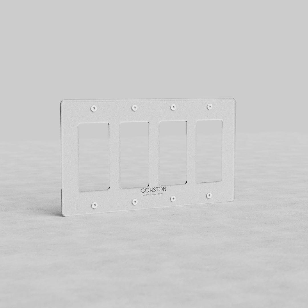 Clear rectangular 4-gang outlet plate (Kew US) with rounded corners, shown upright on a light gray surface.