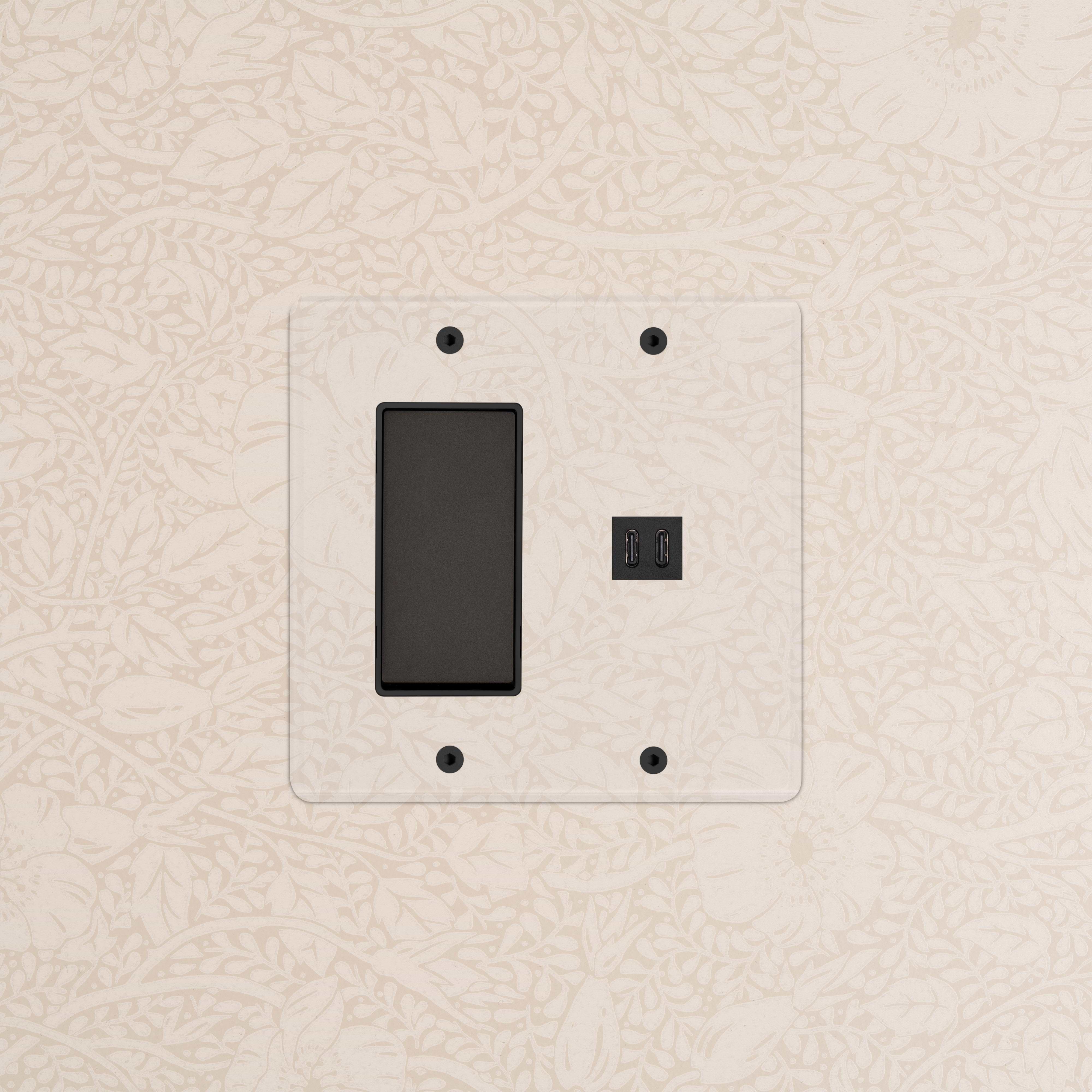 Kew 2G Rocker Switch with Fast Charge USB in Clear Bronze Black, mounted on beige floral wallpaper.