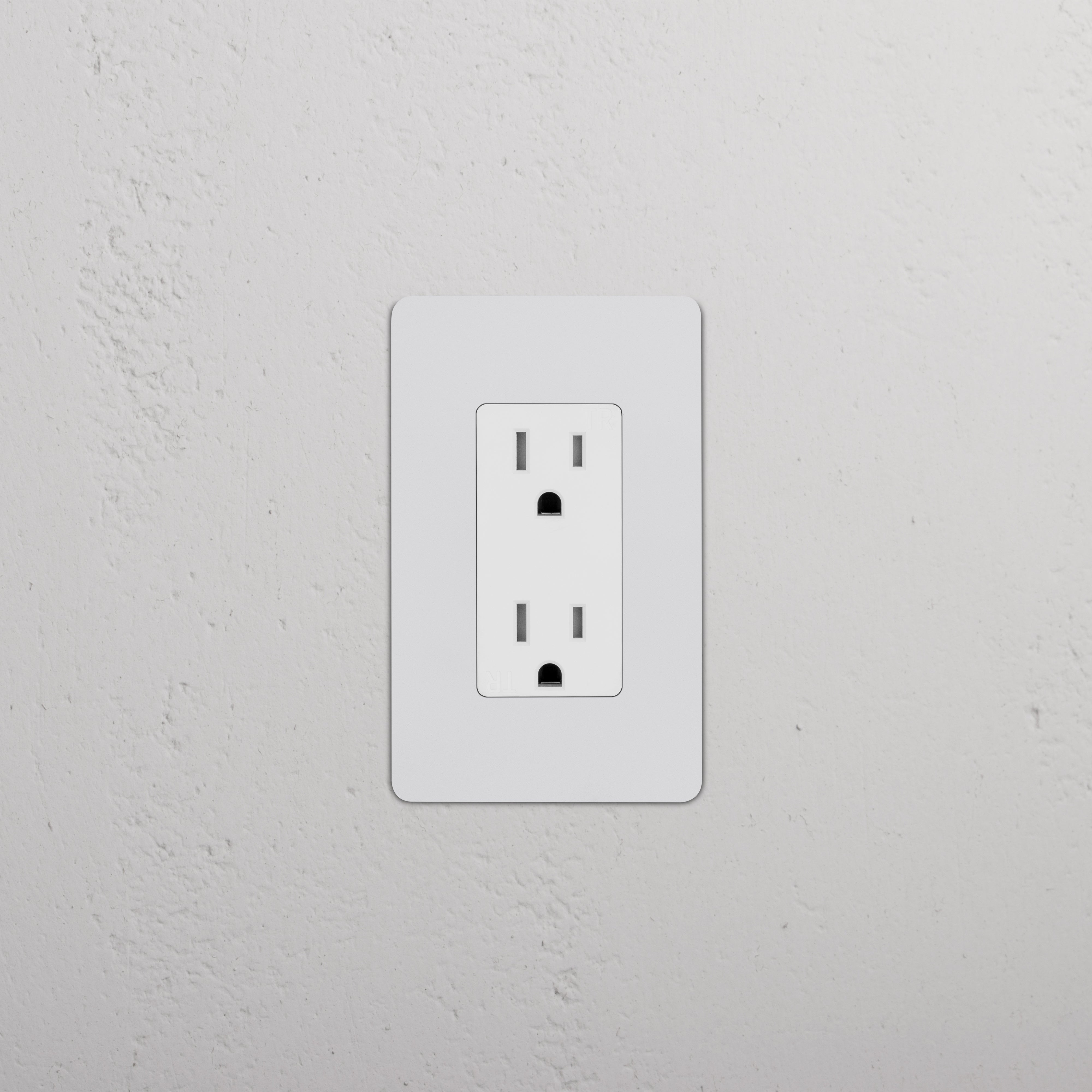 Kew 1G 15A electrical outlet in paintable white finish, mounted on a textured white wall.
