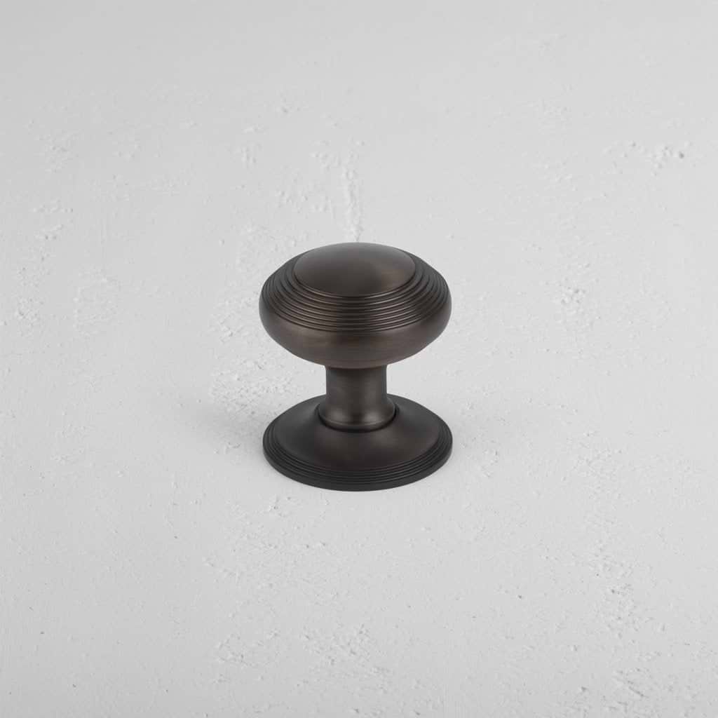 Bronze Poplar Passage Door Knob Set with round shape and concentric circular grooves on display.
