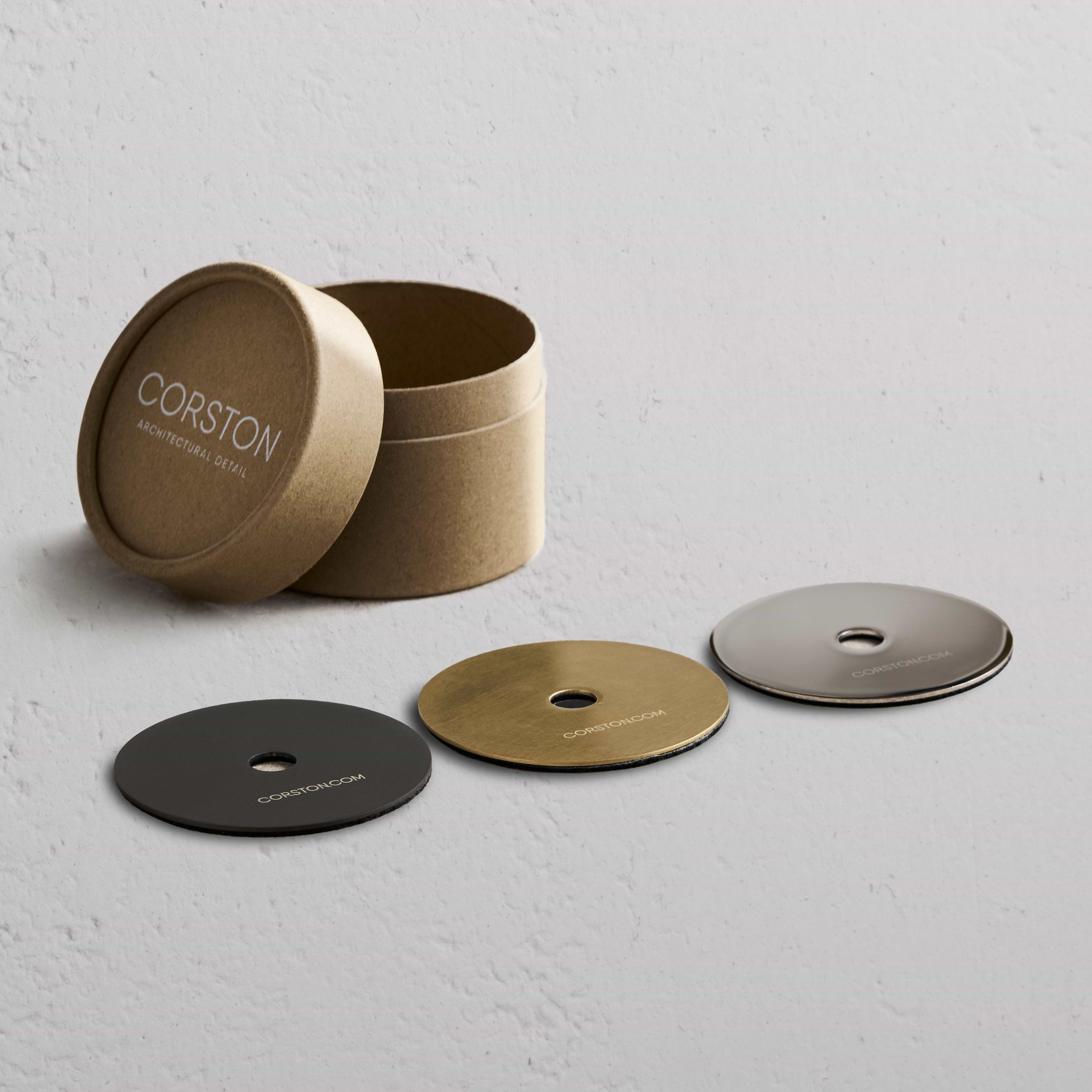 Sample Finish Set box with lid off, showing four labeled metal finish discs and a matching fixture piece.