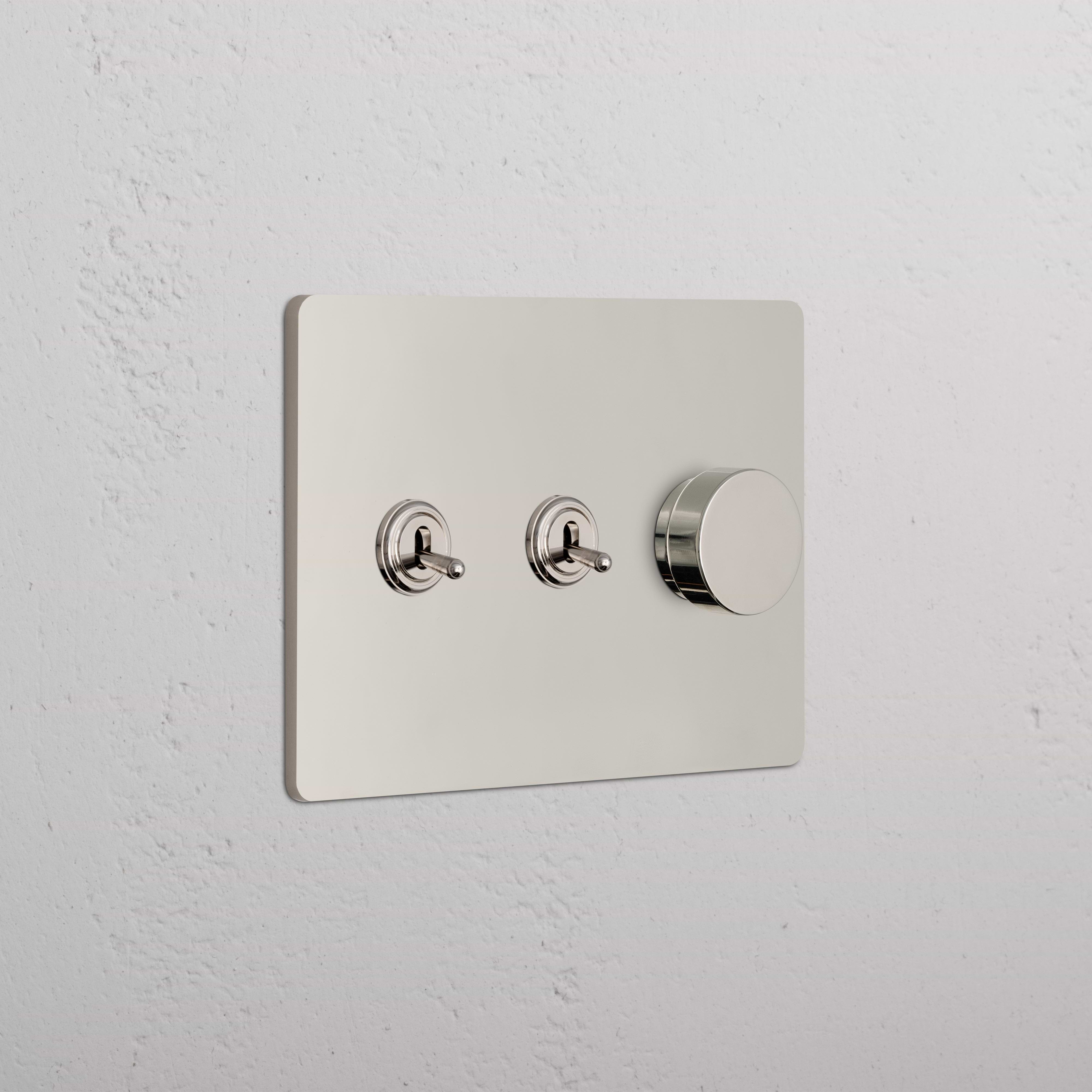 Grove 3G 2x Toggle & Dimmer Switch in polished nickel with two toggles and one dimmer knob on a white wall.