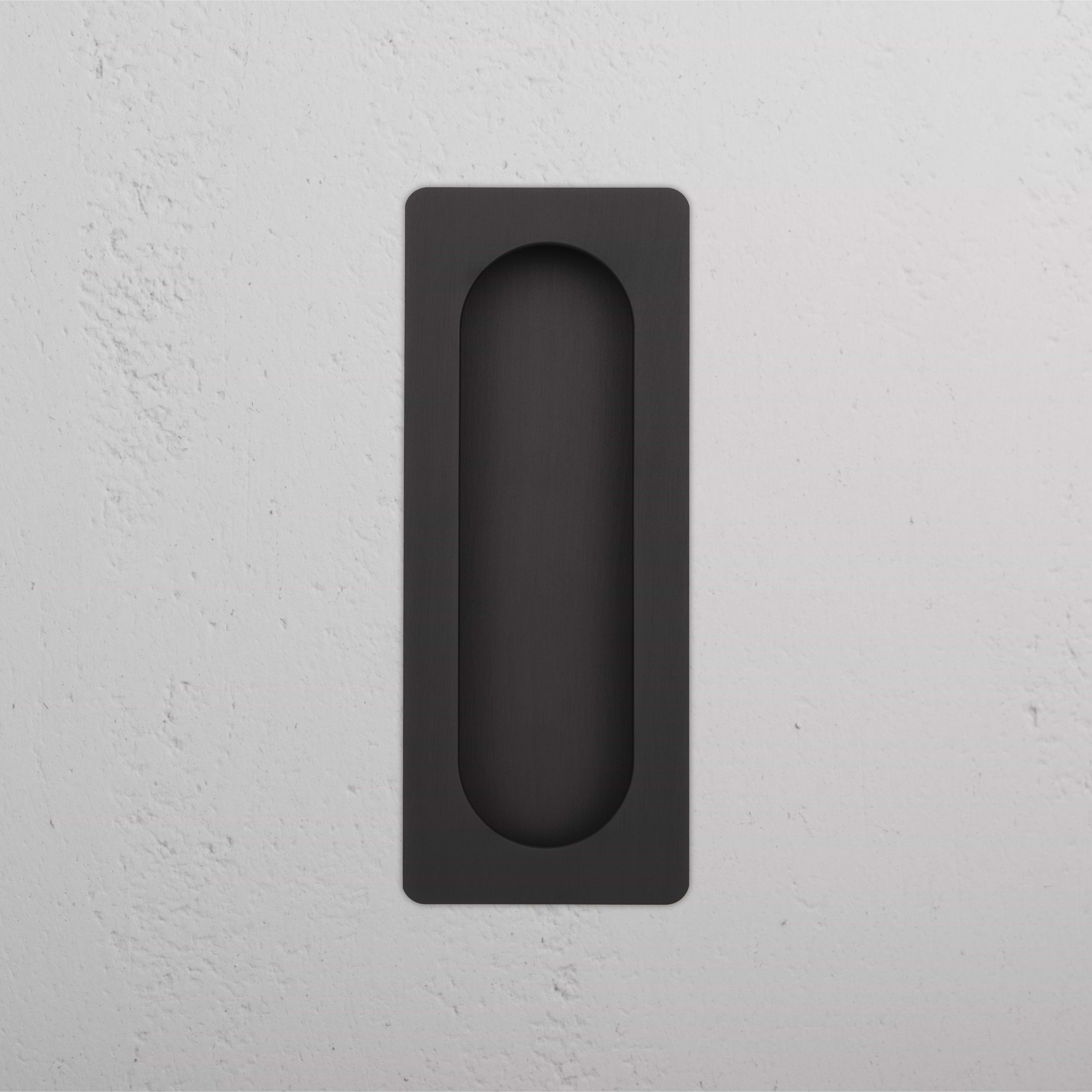 Regent Recessed Medium Pull in bronze finish, mounted flush on a white textured wall.