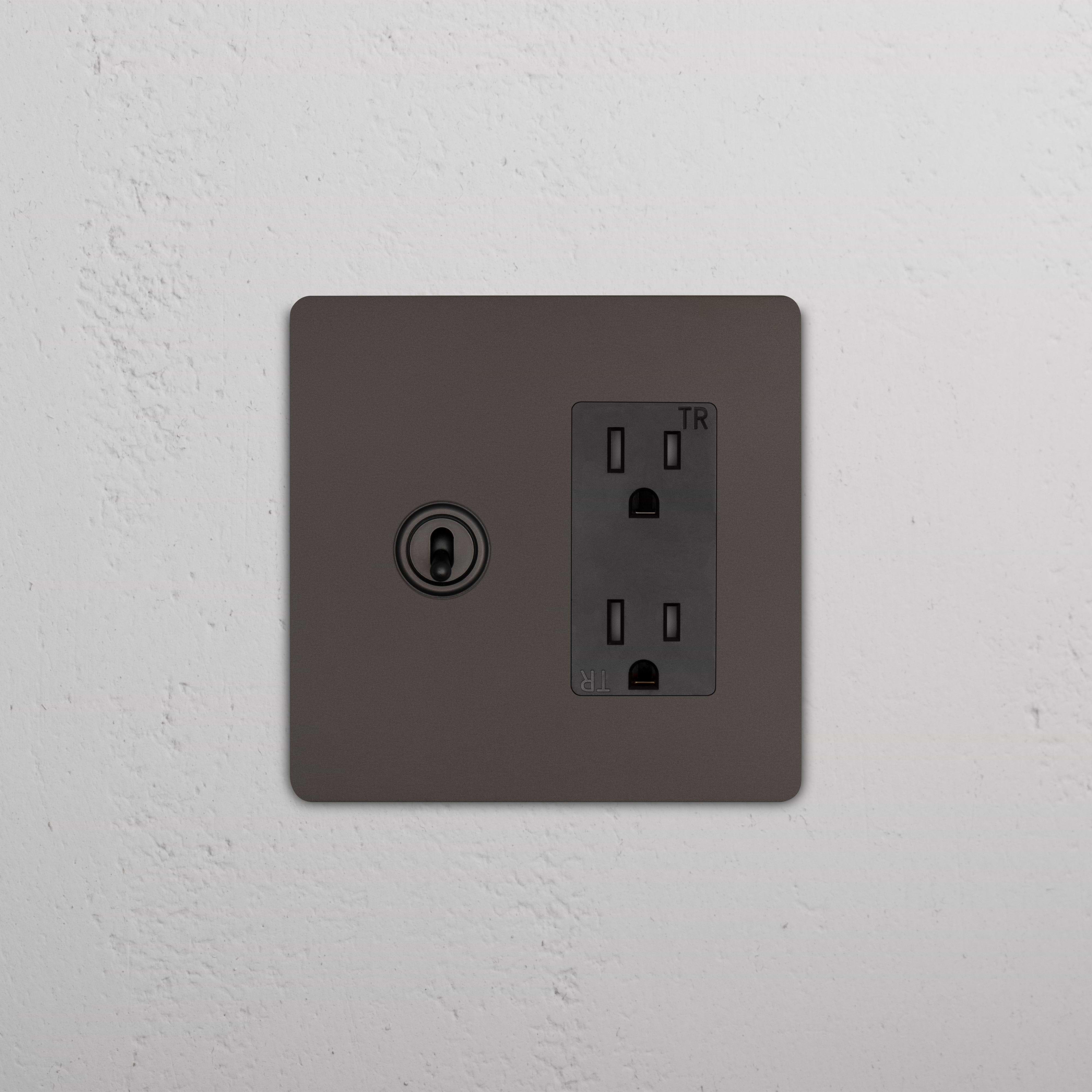 Grove 2G Toggle Switch & Outlet in bronze black with two toggle switches and dual outlets on a white wall.