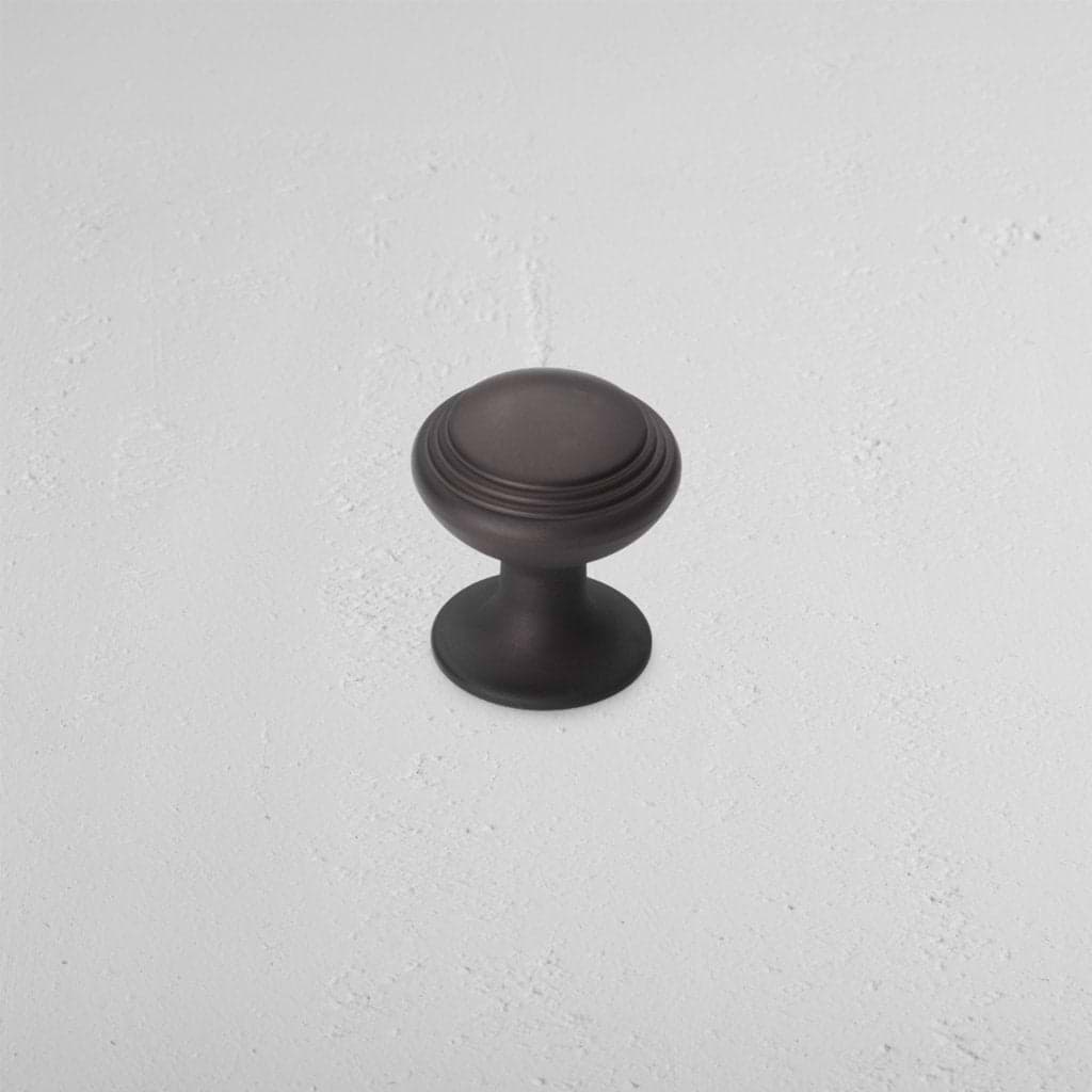 Barlow Furniture Knob Small in bronze with a round, ridged design, shown on a light surface.