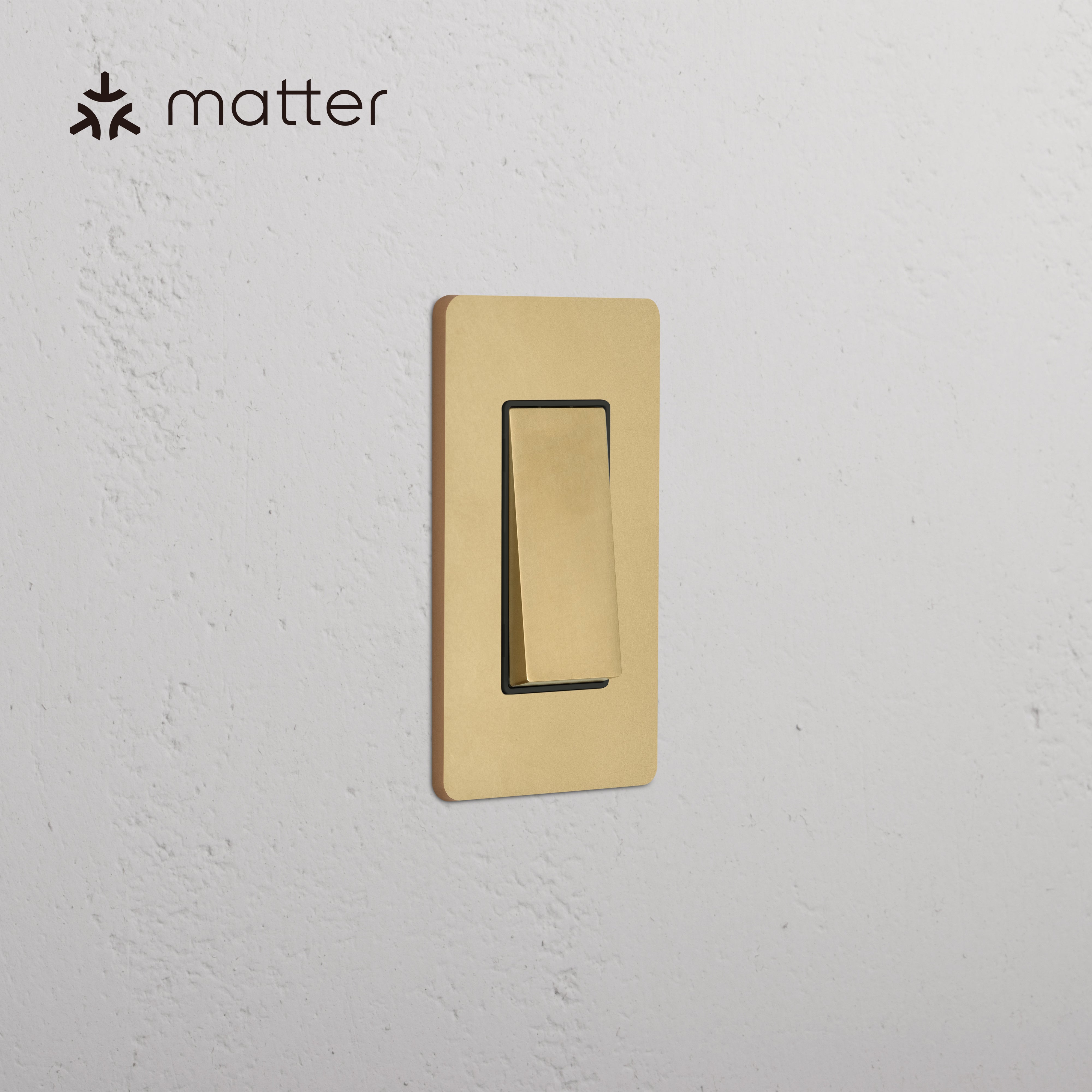 Grove 1G Smart Retractive Rocker Switch in Antique Brass Black, mounted on a white wall, Matter-enabled.