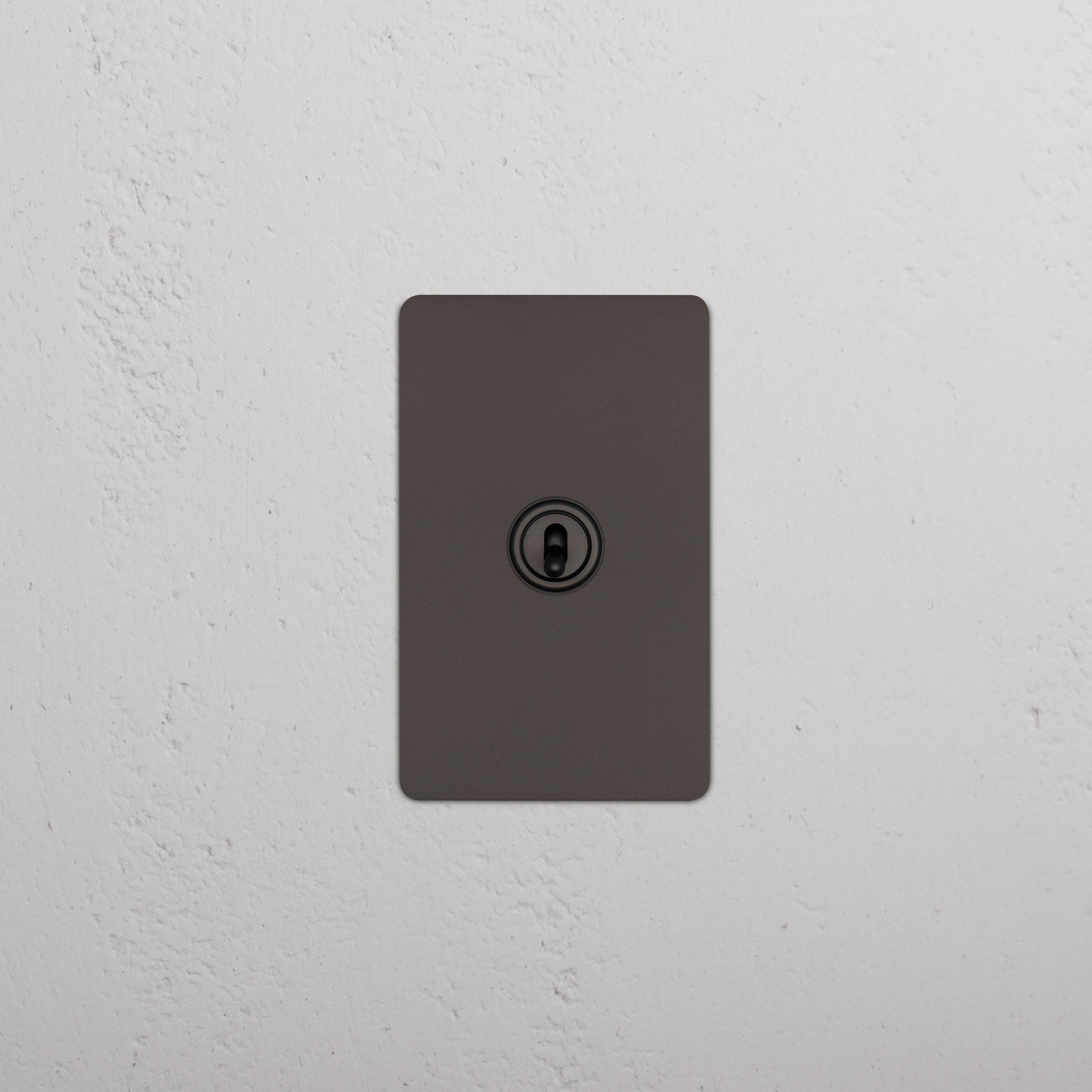 Kew 1G Four Way Toggle Switch in bronze, mounted on a wall, showing four toggles for light control.