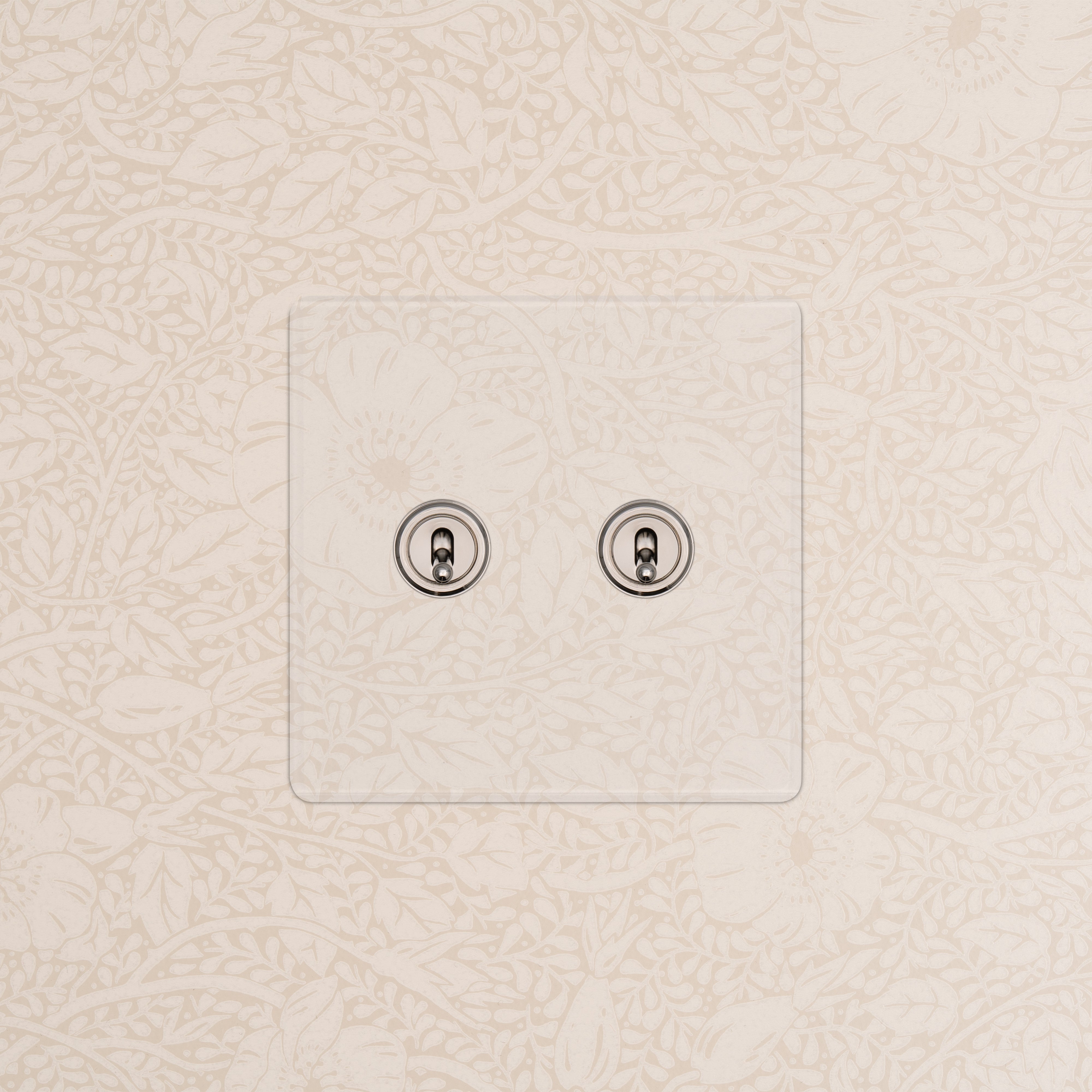 Kew 2G Toggle Switch in Clear Polished Nickel finish with two chrome toggles on floral-patterned wallpaper.