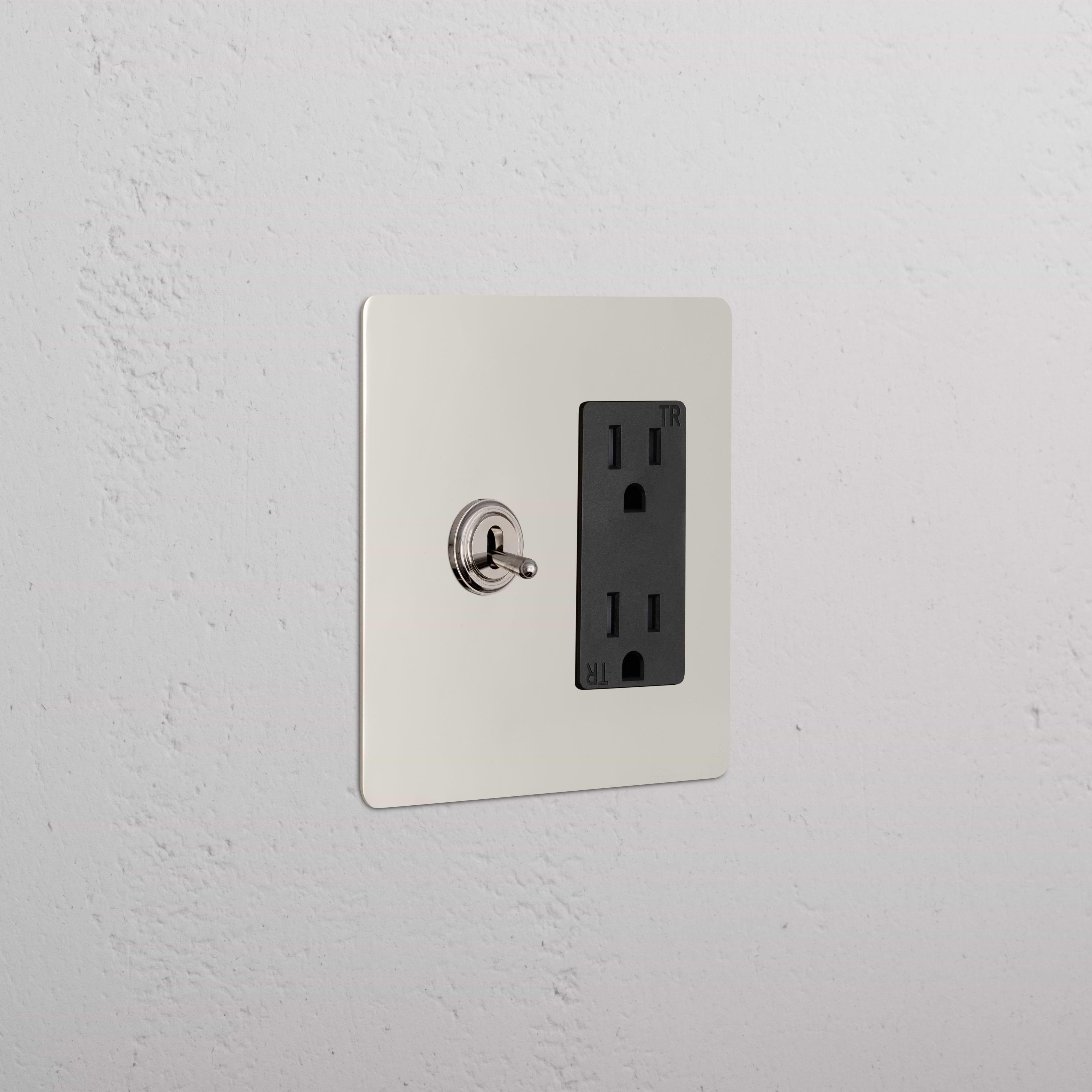 Kew 2G Toggle Switch & Outlet in polished nickel black with left toggle switch and right dual outlet on wall.