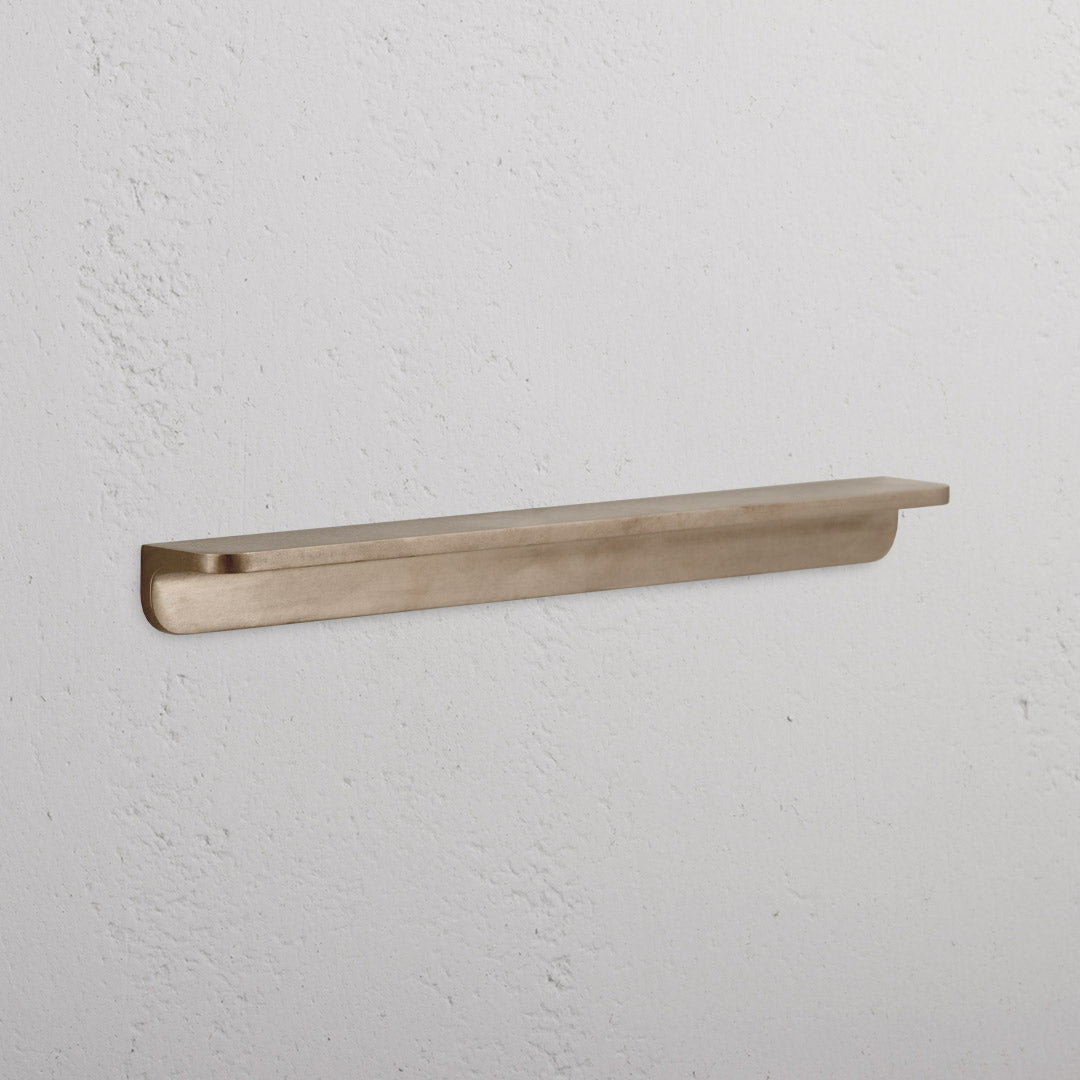 Medium antique brass Oxford furniture handle with a smooth, rounded design, shown against a white background.