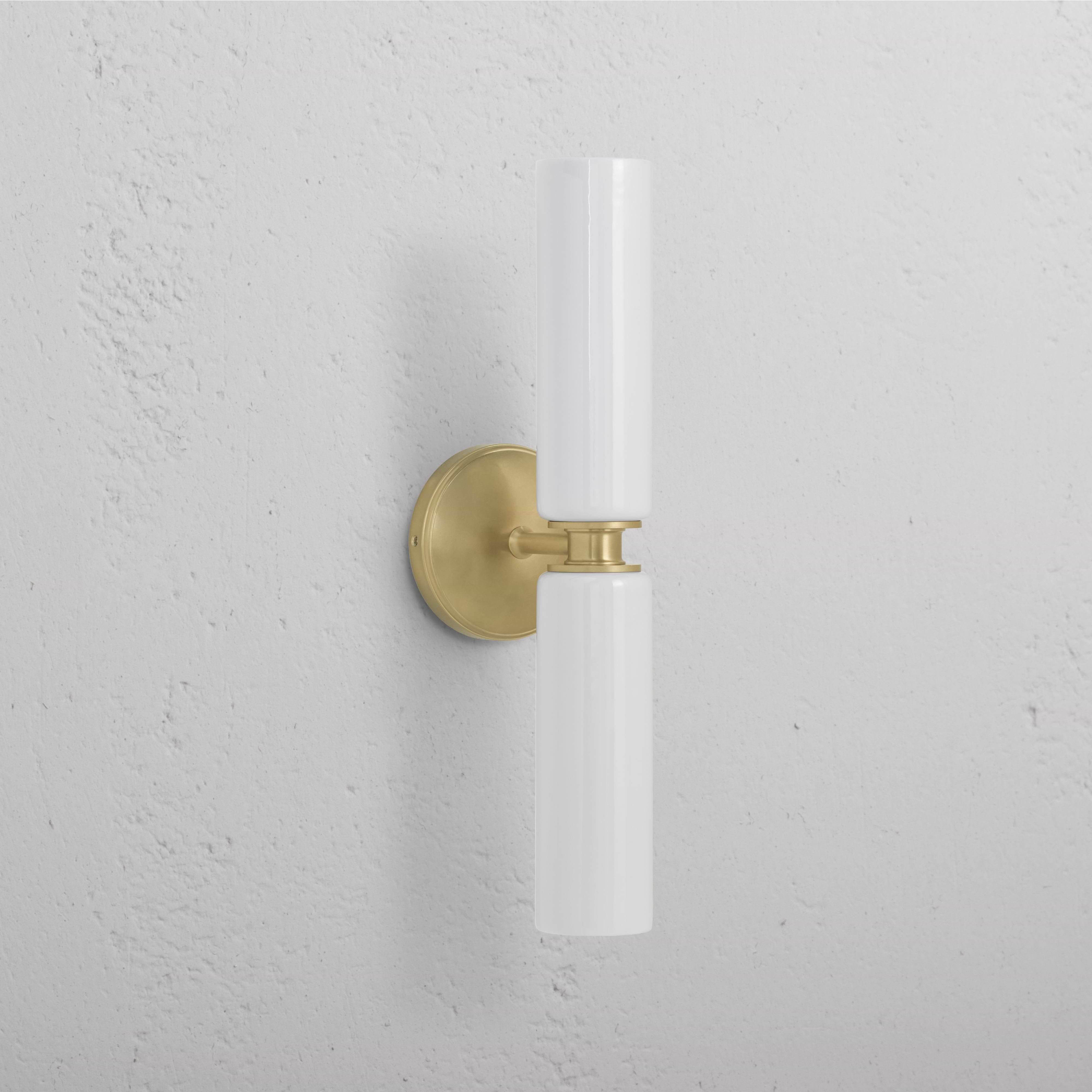 Claremont Medium Wall Light in antique brass with fine porcelain cylindrical shade, mounted on a wall.