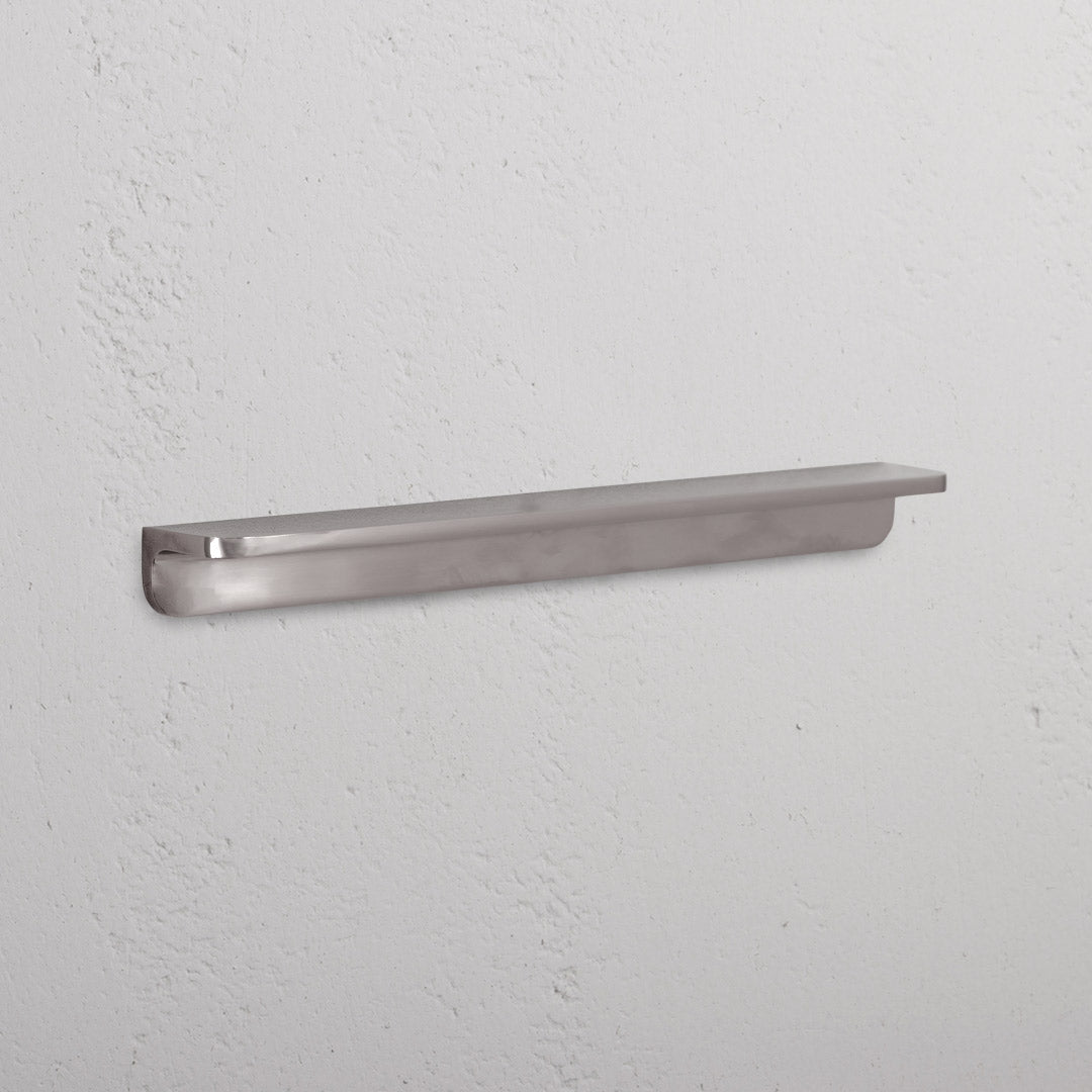 Medium-sized Oxford Furniture Handle in polished nickel finish, for cabinets or drawers, mounted on white surface.