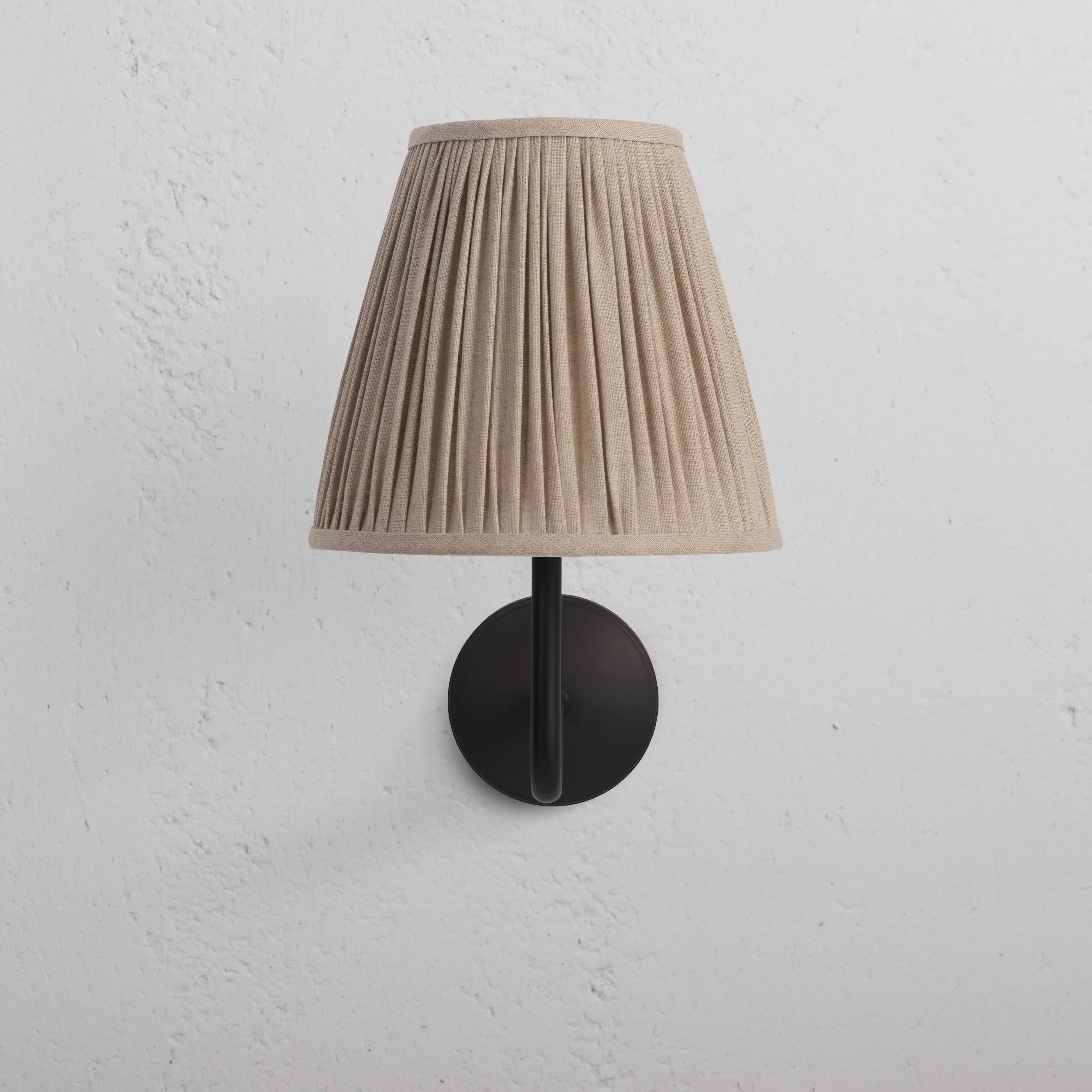 Large Malvern Wall Light in natural beige with bronze accents and a pleated fabric shade on a black base.