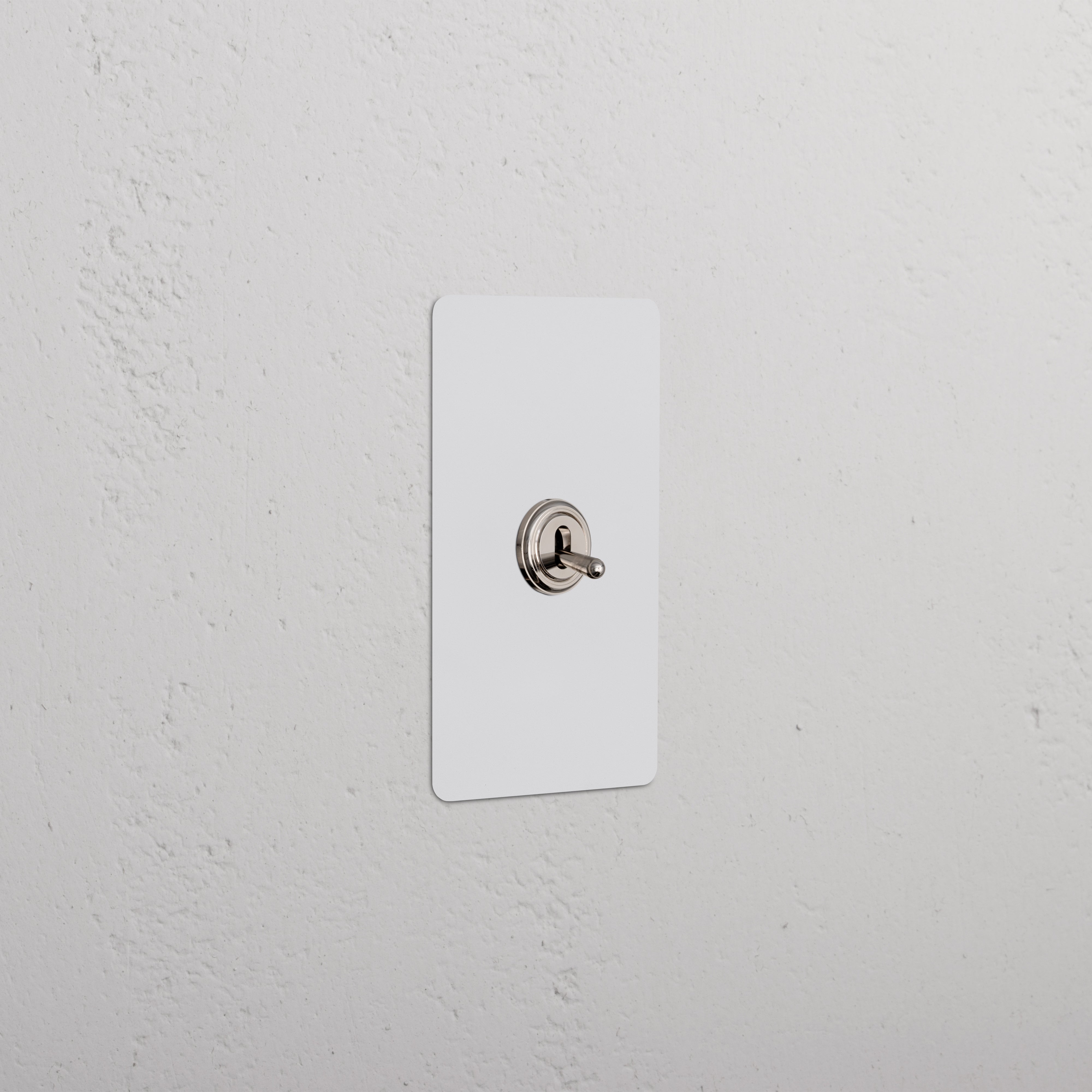 Kew 1G Four Way Toggle Switch in paintable polished nickel with a white rectangular plate on a wall.