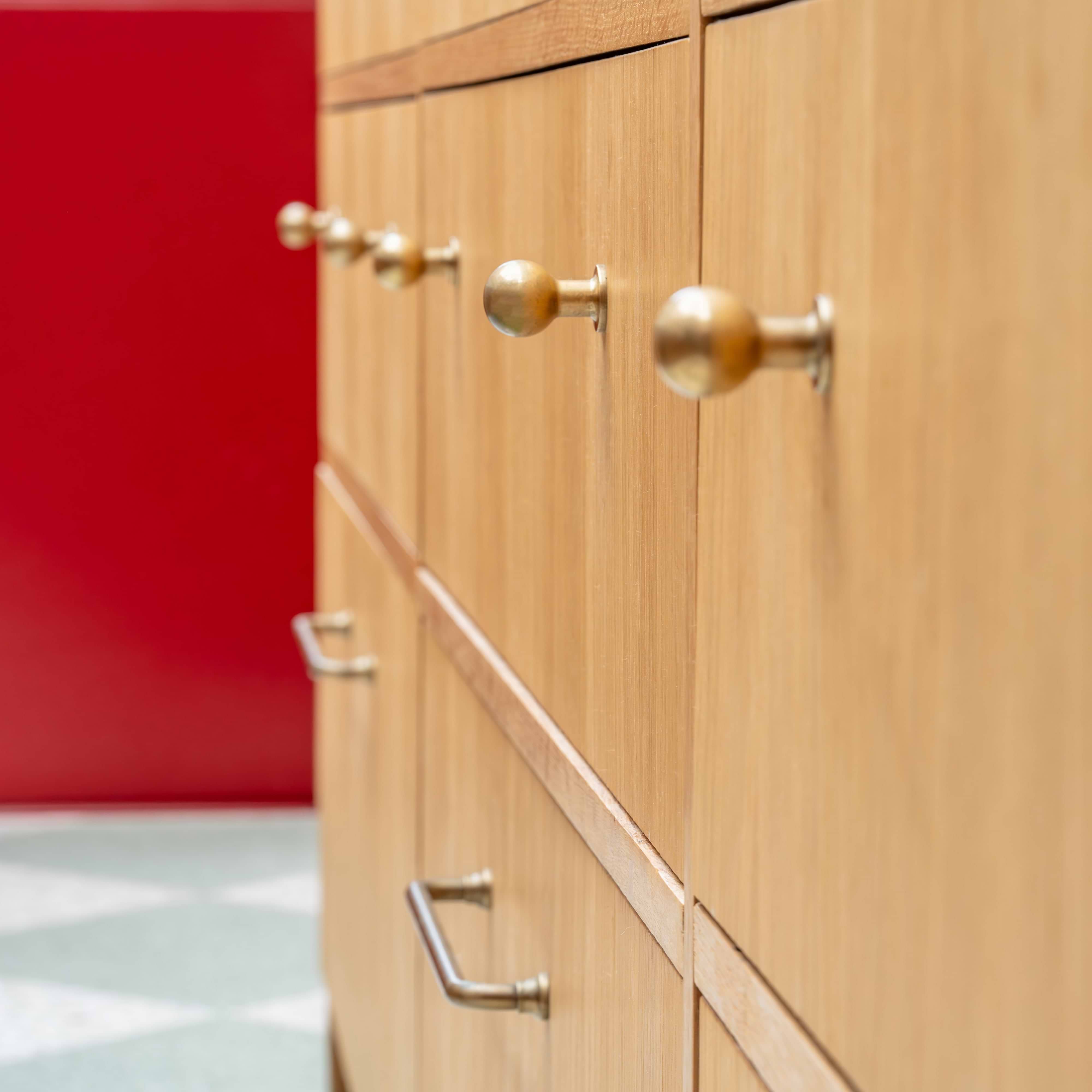 Close-up of a cabinet door featuring the Bayswater Furniture Knob Small in antique brass finish.