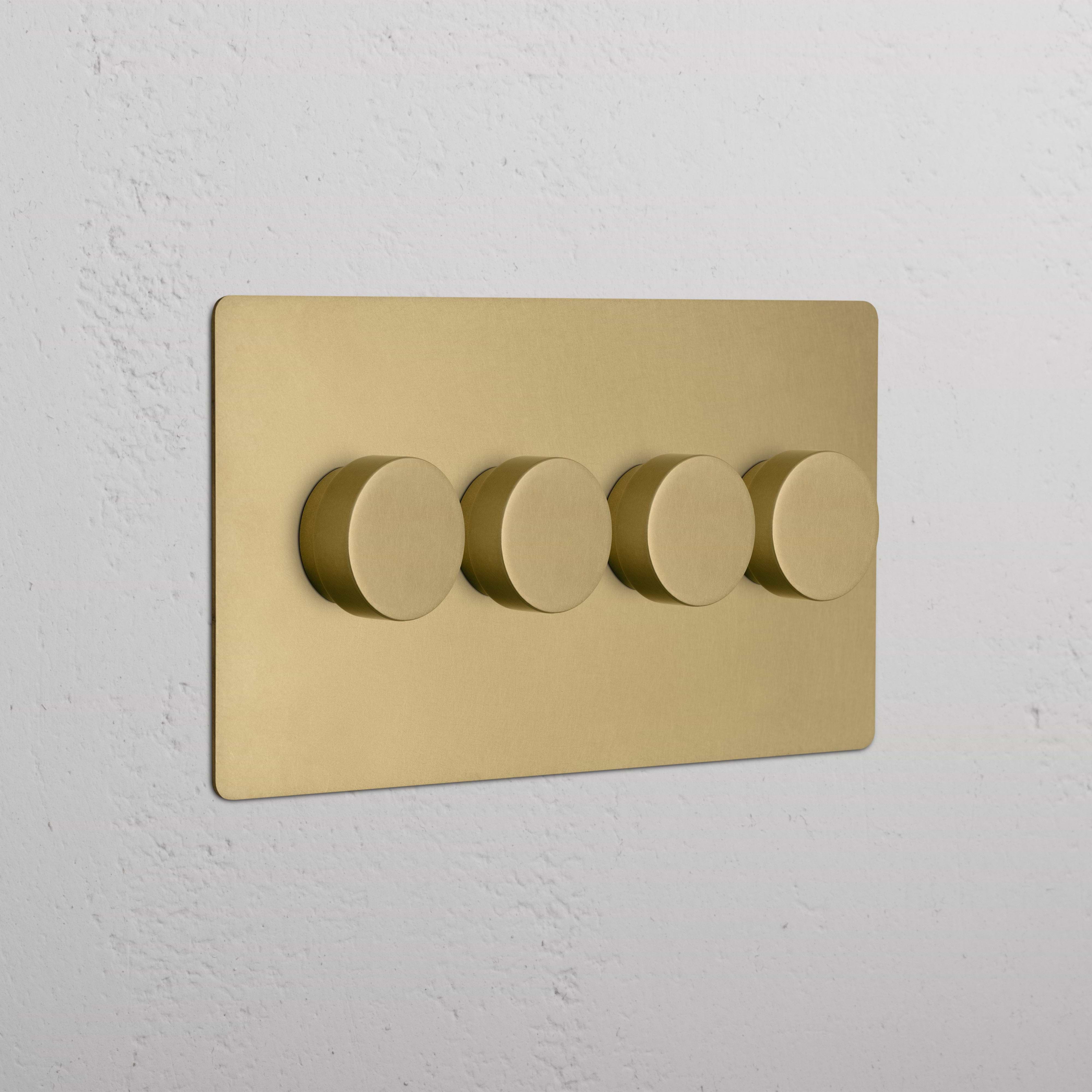 Kew 4G Dimmer Switch in Antique Brass with four round dimmer knobs mounted on a wall.