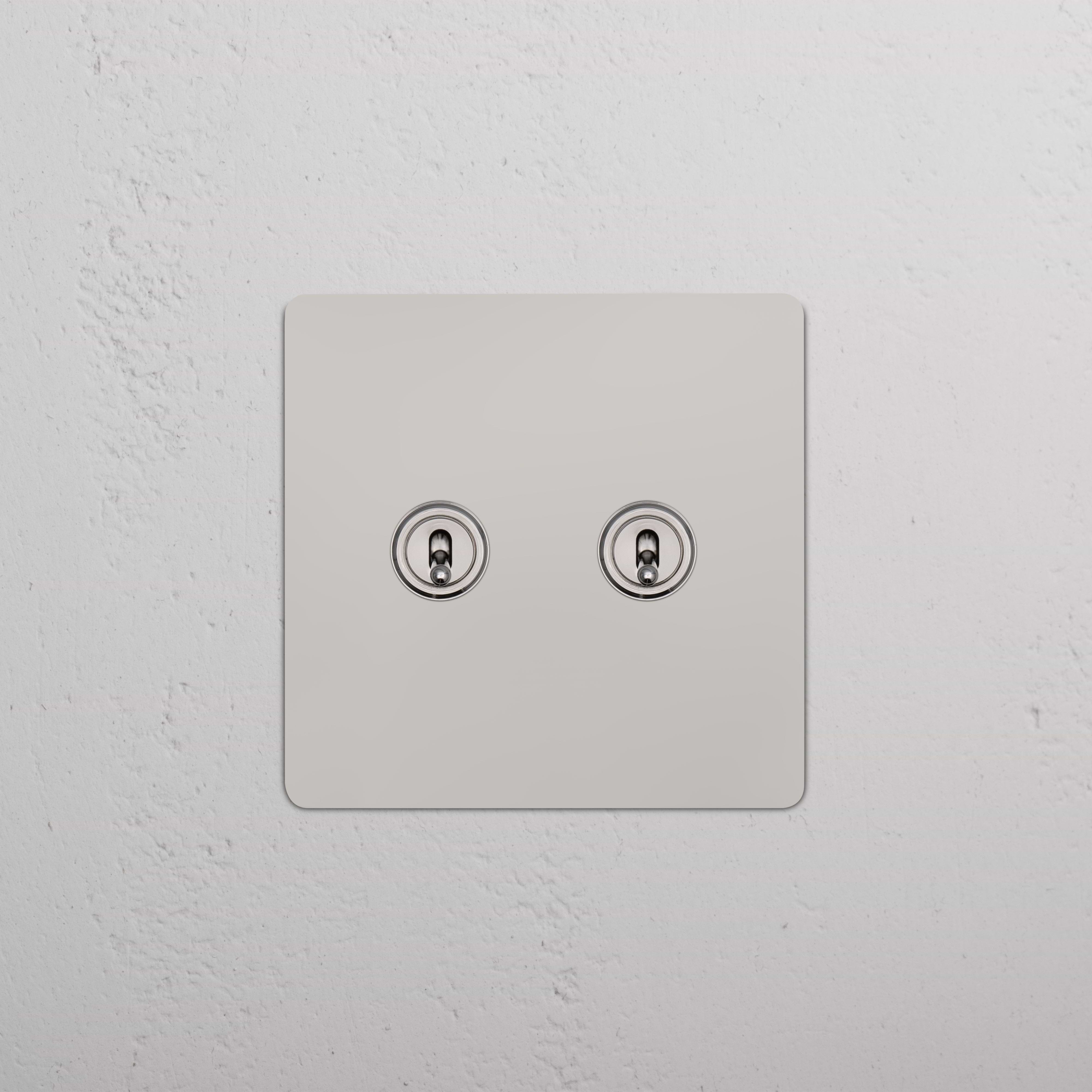 Kew 2G Toggle Switch in polished nickel finish with two toggle switches, mounted on a wall.