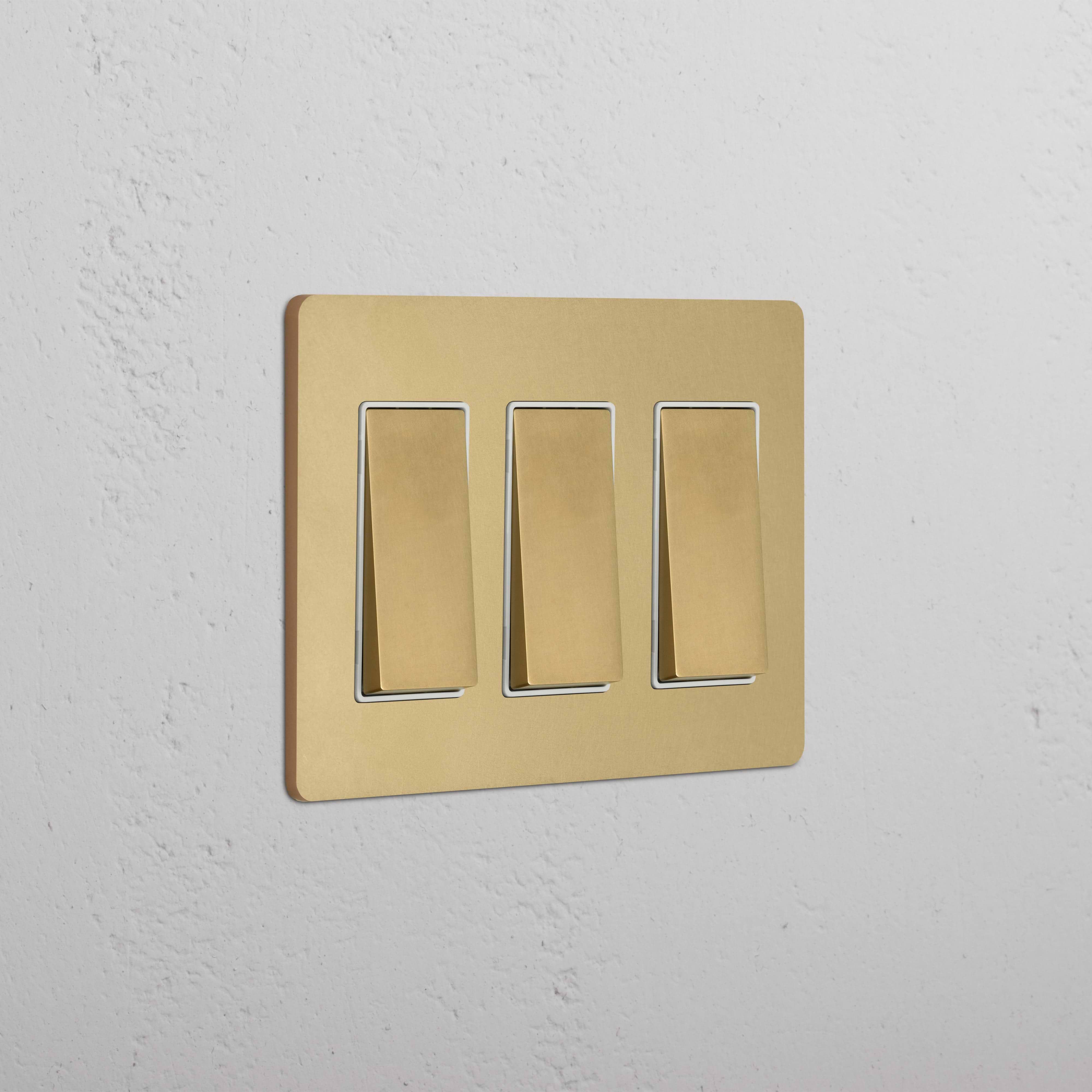 Grove 3G Rocker Switch in antique brass white finish, with three white rectangular switches on a brass plate.
