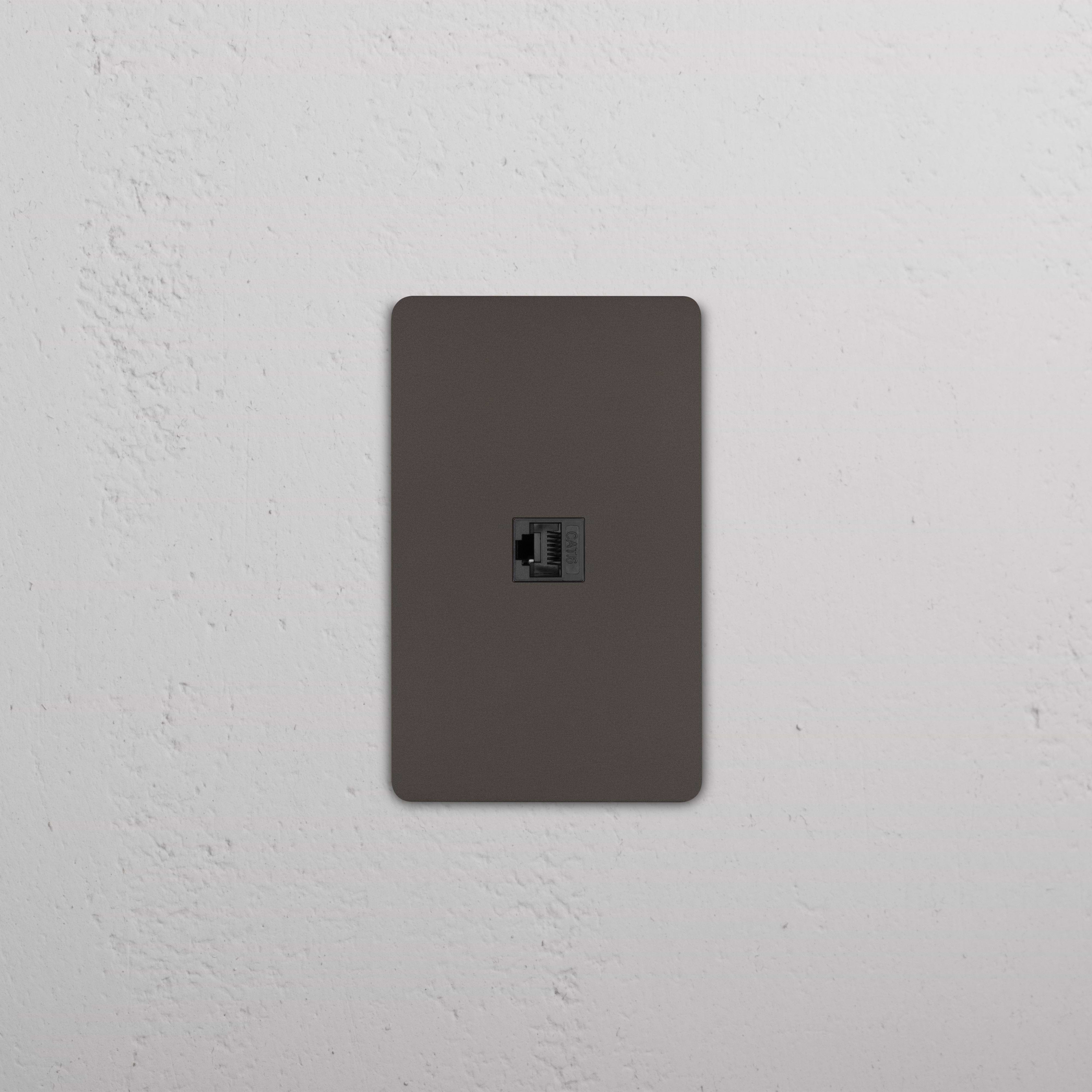 Grove 1G CAT 6 Keystone - Bronze Black wall plate featuring a single Ethernet port, shown installed on a wall.