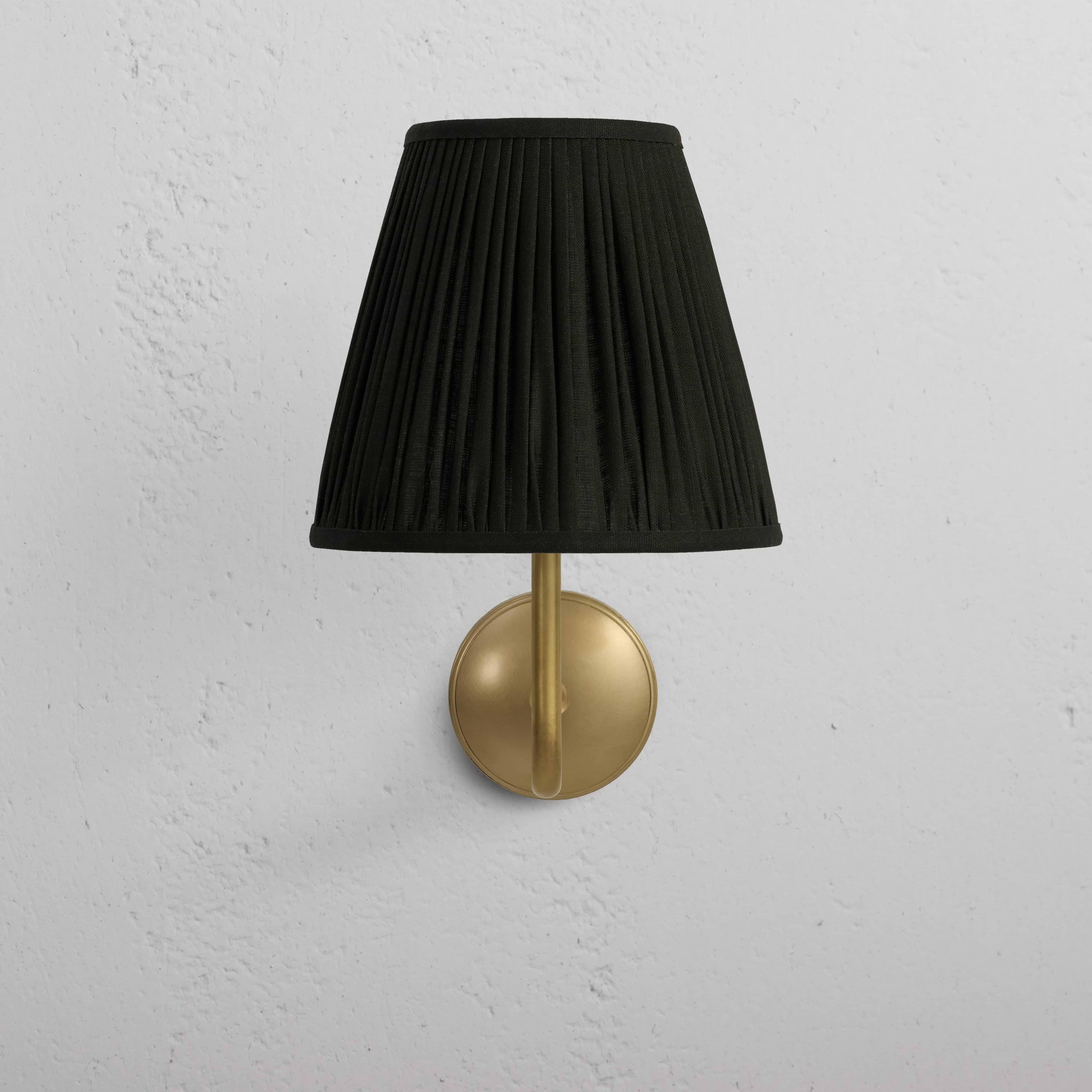 Large Malvern Wall Light in Deep Green with antique brass base and curved shade, mounted on a white wall.