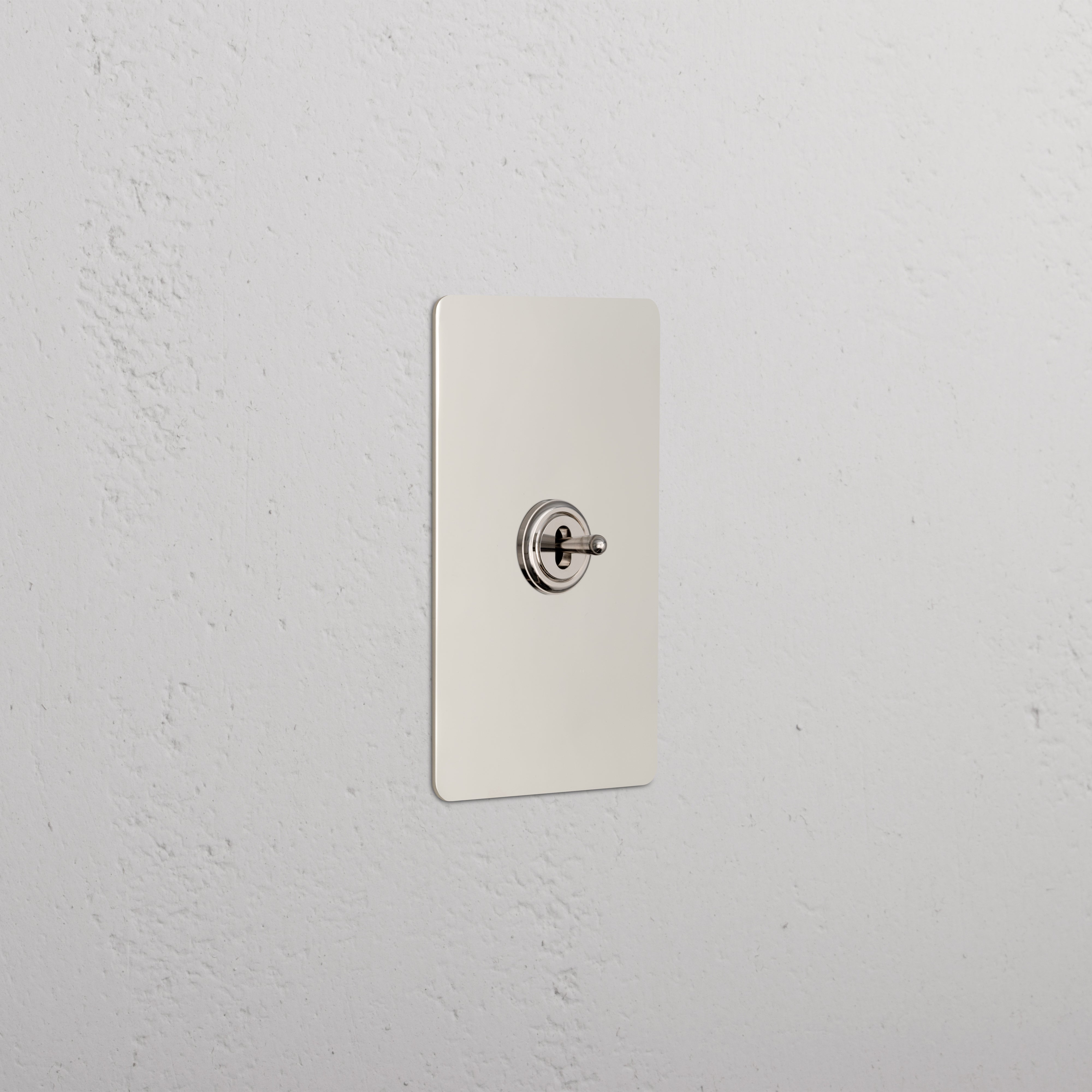 Kew 1G Center Retractive Toggle Switch in polished nickel mounted on a rectangular plate.